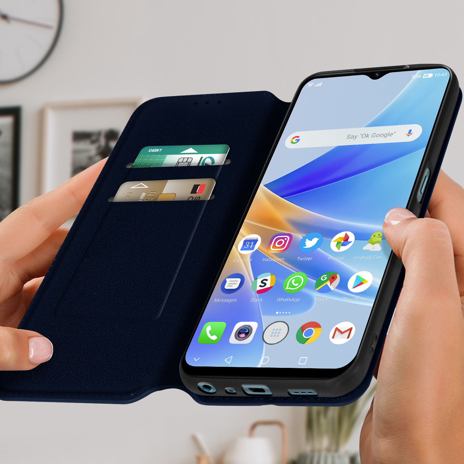 Una persona che tiene un telefono in una custodia blu, con lo schermo del telefono che mostra le app.