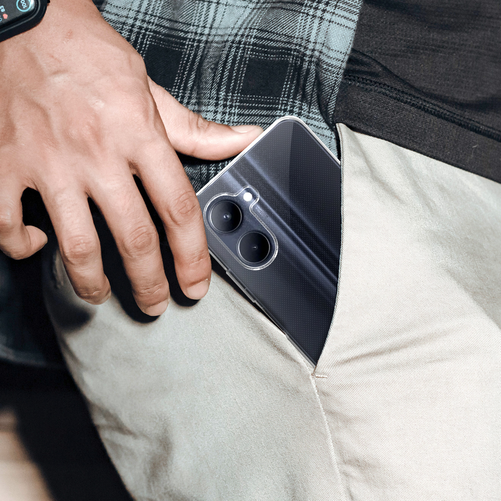 Una mano nella tasca di pantaloni beige tiene una custodia trasparente con un telefono dentro.