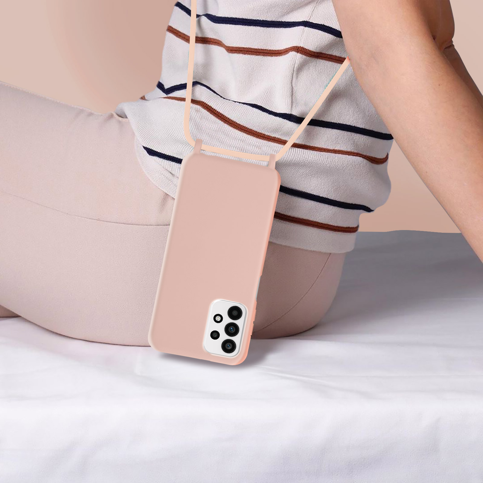 Rosa Handyhülle mit einem Telefon darin. Die Handyhülle befindet sich auf einer weißen Oberfläche. Ein Gurt ist befestigt.