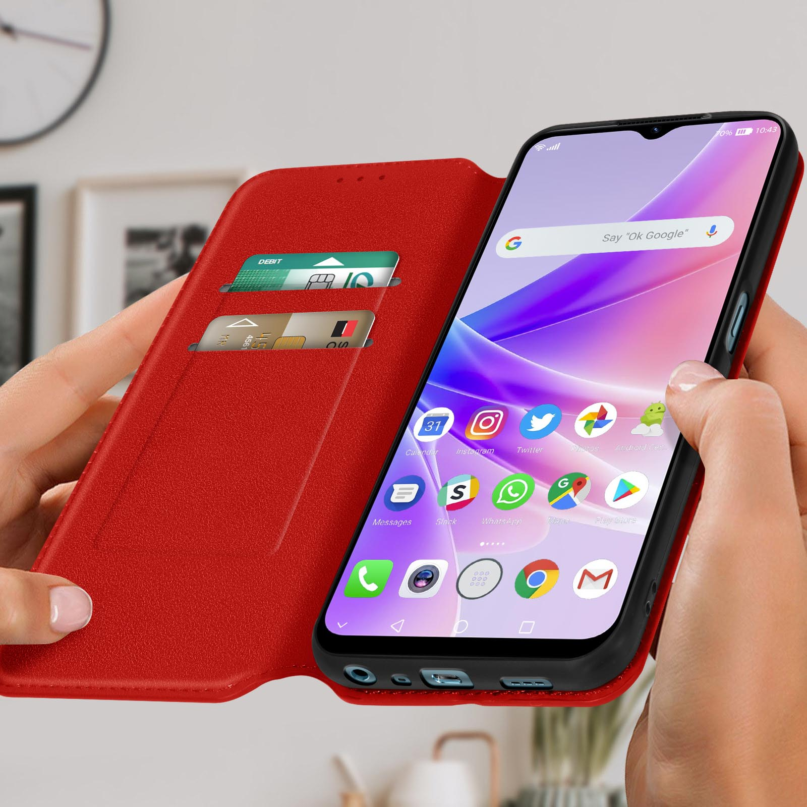 Una persona tiene una custodia rossa con un telefono dentro. Lo schermo mostra app e fessure per carte.
