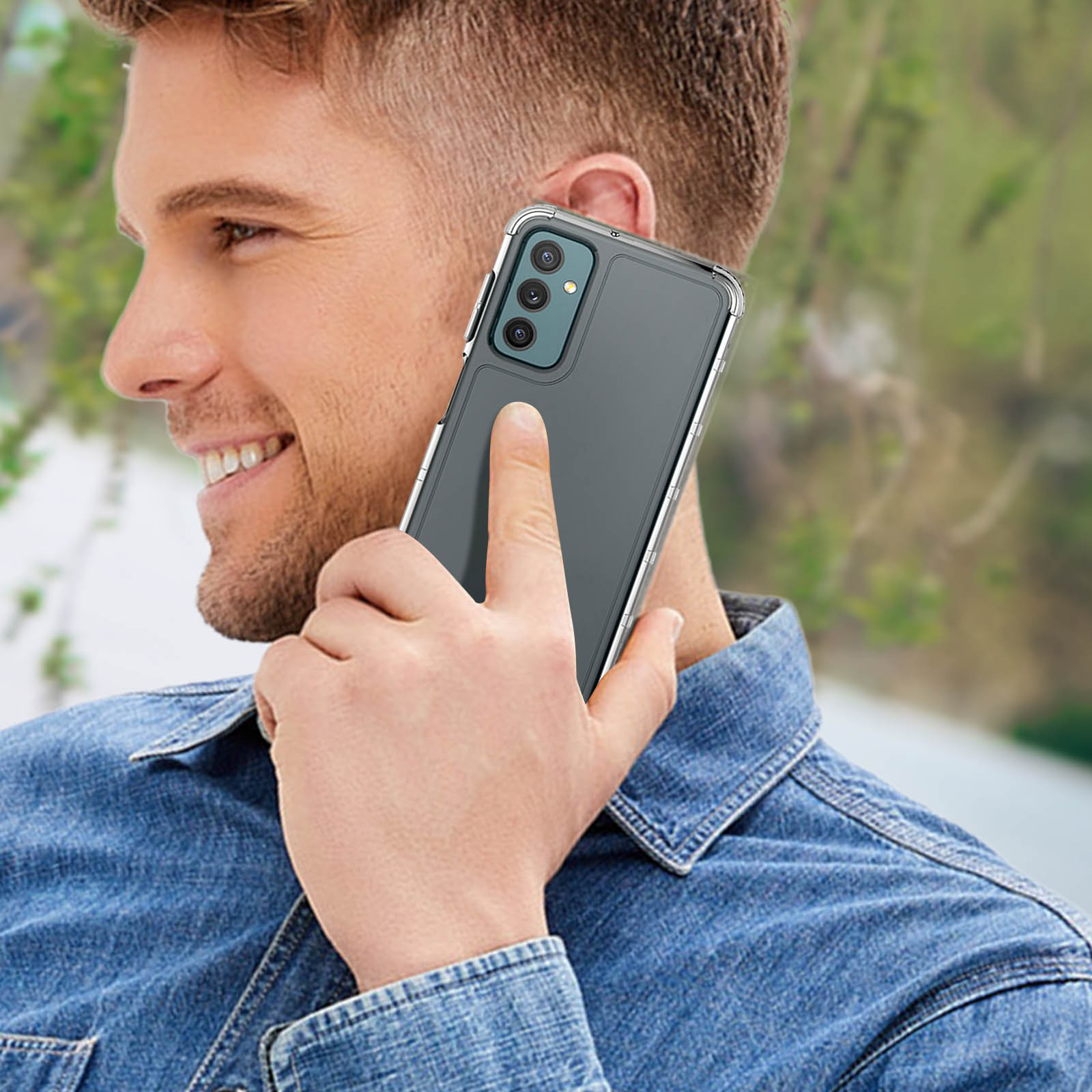 Hombre sostiene teléfono con funda protectora en la oreja, sonriendo, con fondo verde.