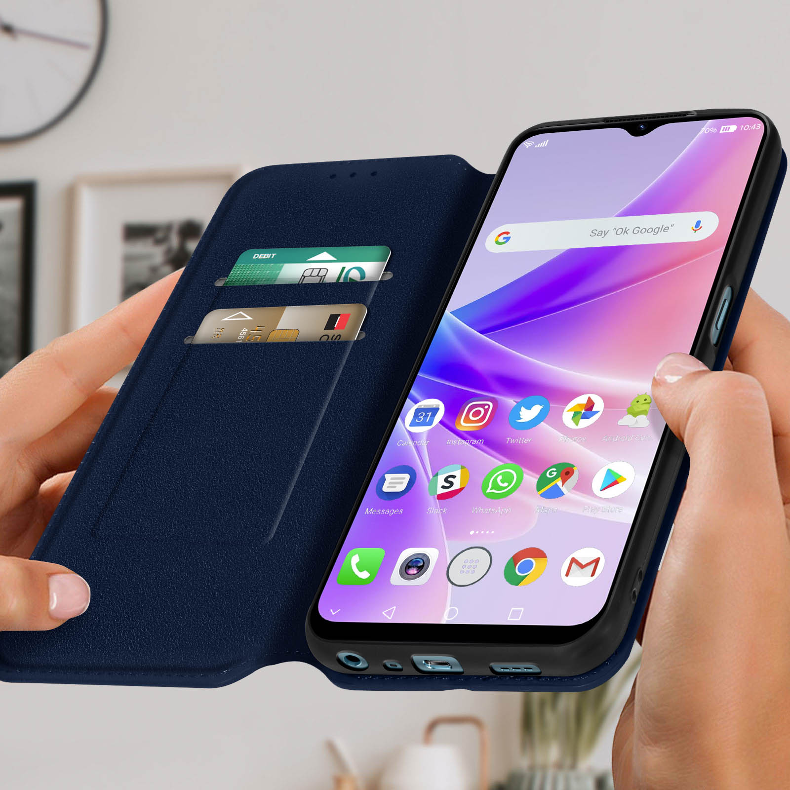 Una custodia per telefono blu aperta, che tiene un telefono con carte di credito in tasca. Le mani tengono la custodia.
