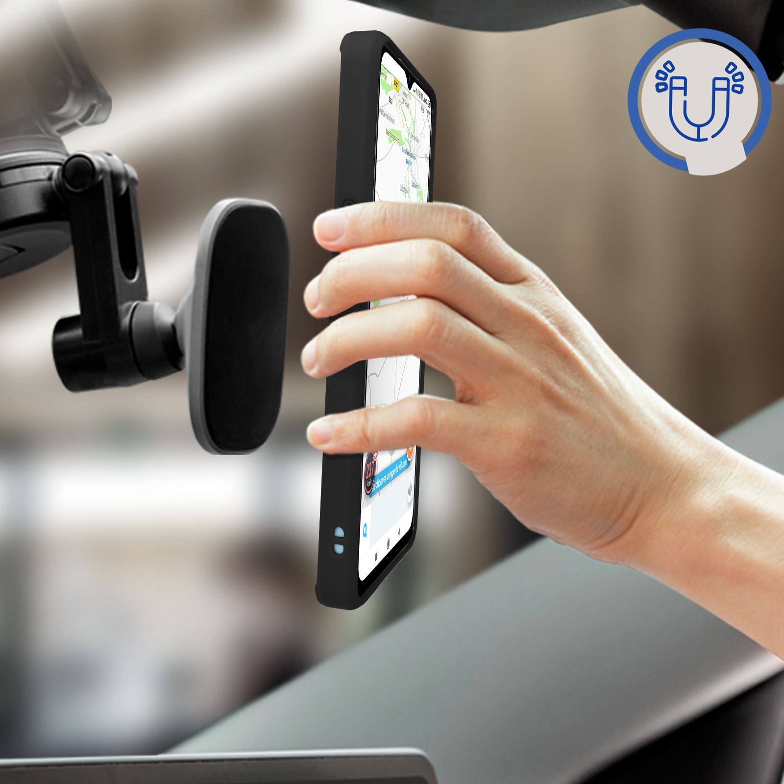 Mano che tiene un telefono con app mappe aperta, accanto a supporto per telefono auto. Interno grigio.