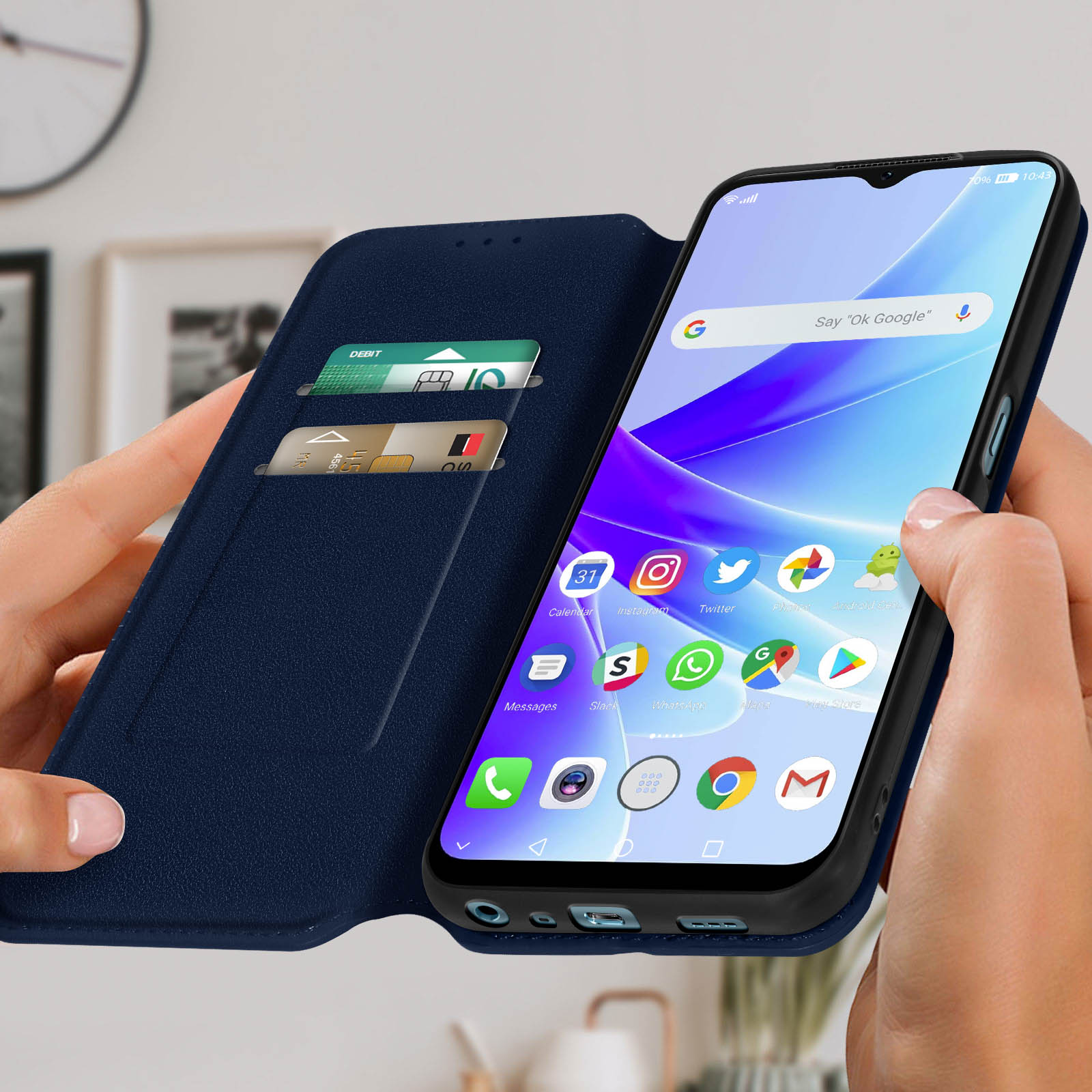 Un telefono in una custodia blu viene tenuto in mano. Lo schermo mostra le icone delle app dei social media.