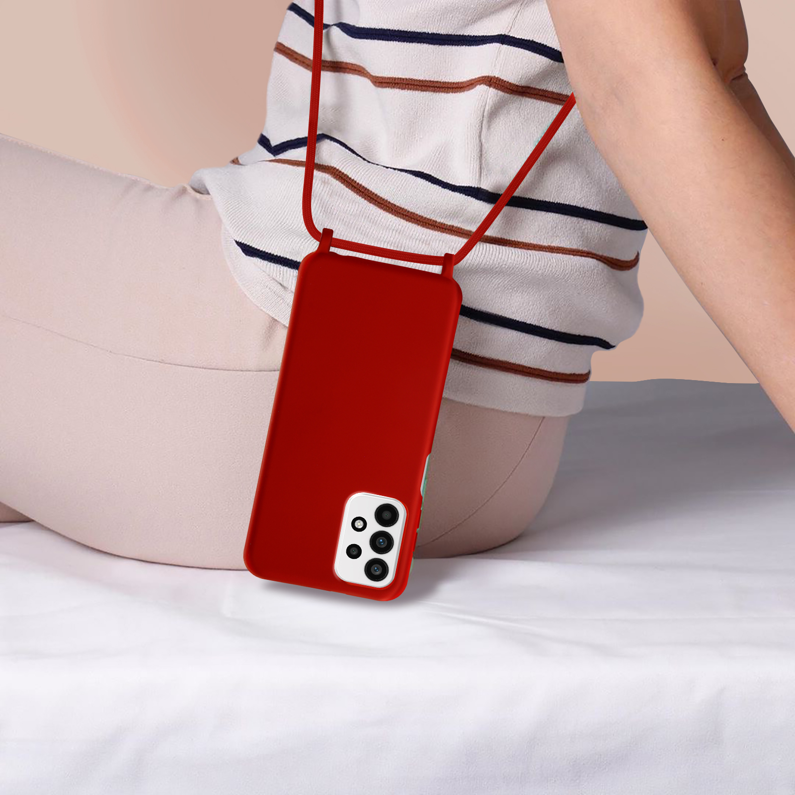 Een vrouw draagt ​​een rode telefoonhoes met een nekriem. De hoes ligt op haar schoot.