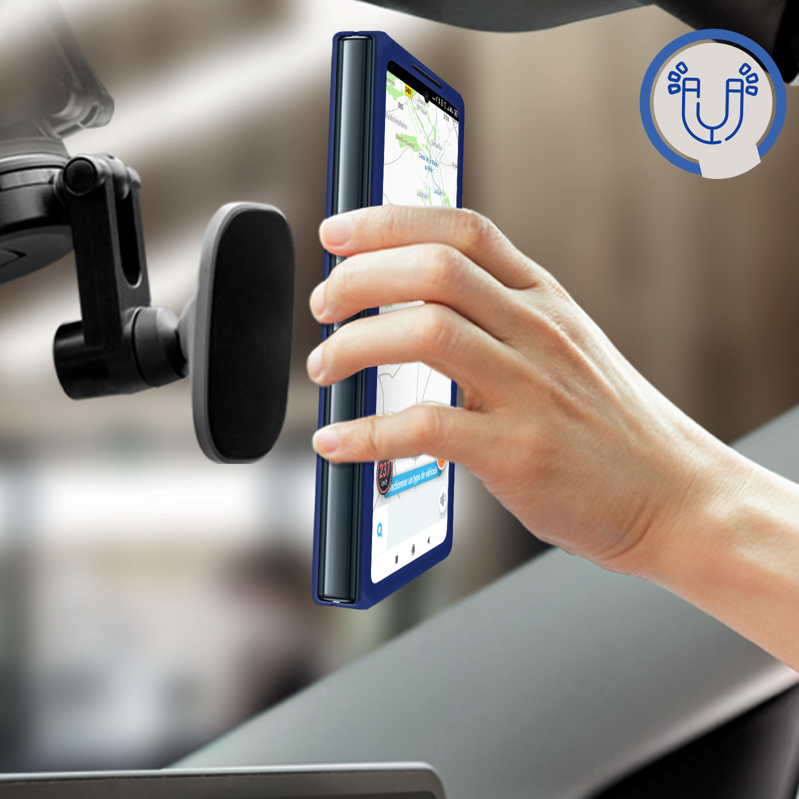 Una mano tiene un telefono con custodia blu. Il telefono è montato su un supporto per auto.