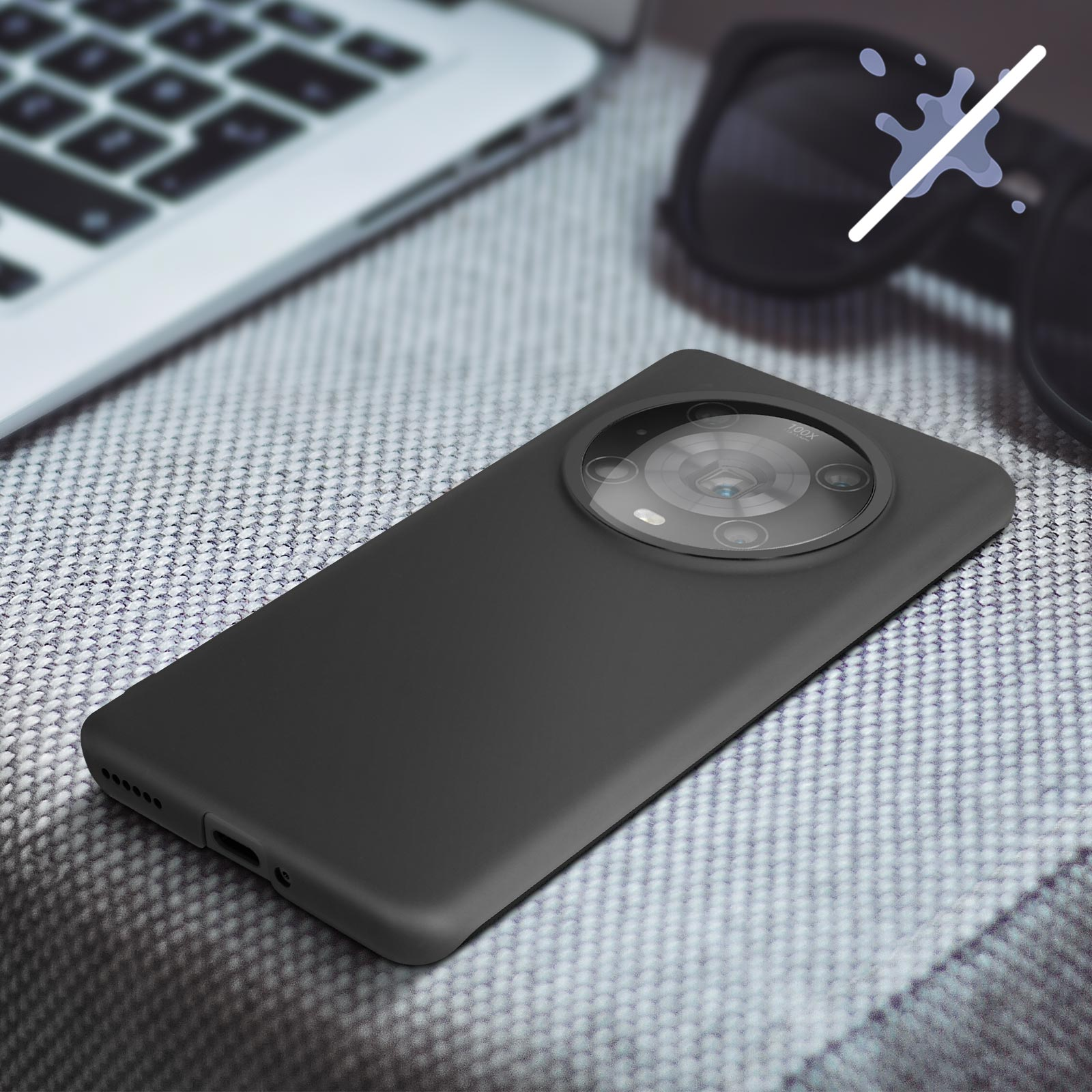 Telefono nero con protuberanza della fotocamera e custodia grigia. Il telefono è su una superficie grigia.