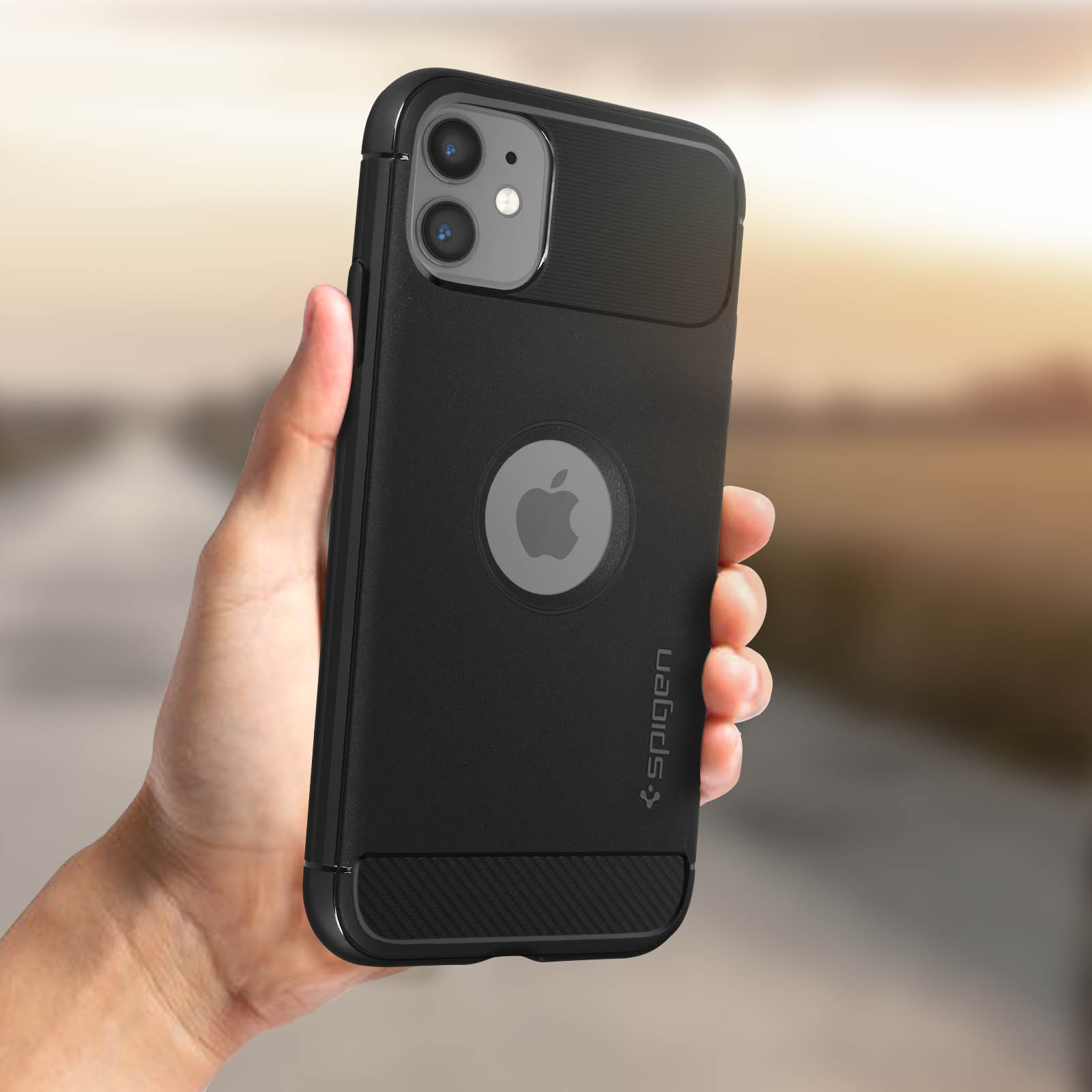 Mano che tiene un telefono nero con logo Apple in una custodia nera.