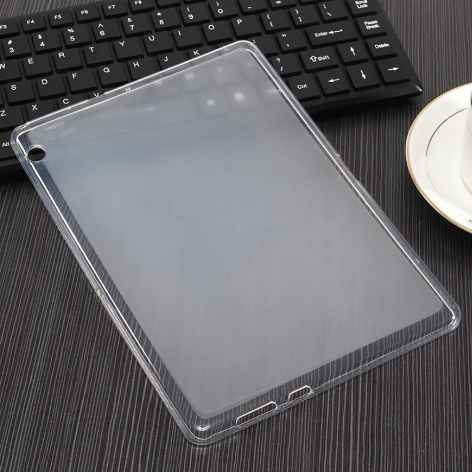 Transparente Tablet-Hülle, flach. Zeigt eine transparente Abdeckung über einer Tastatur und einer Tasse.