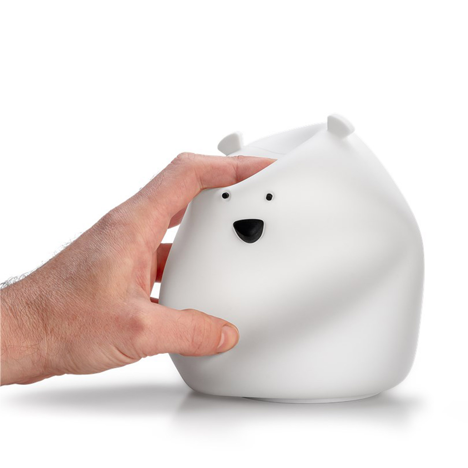 Weisse Eisbärfigur, gehalten von einer Hand, weisser Hintergrund.