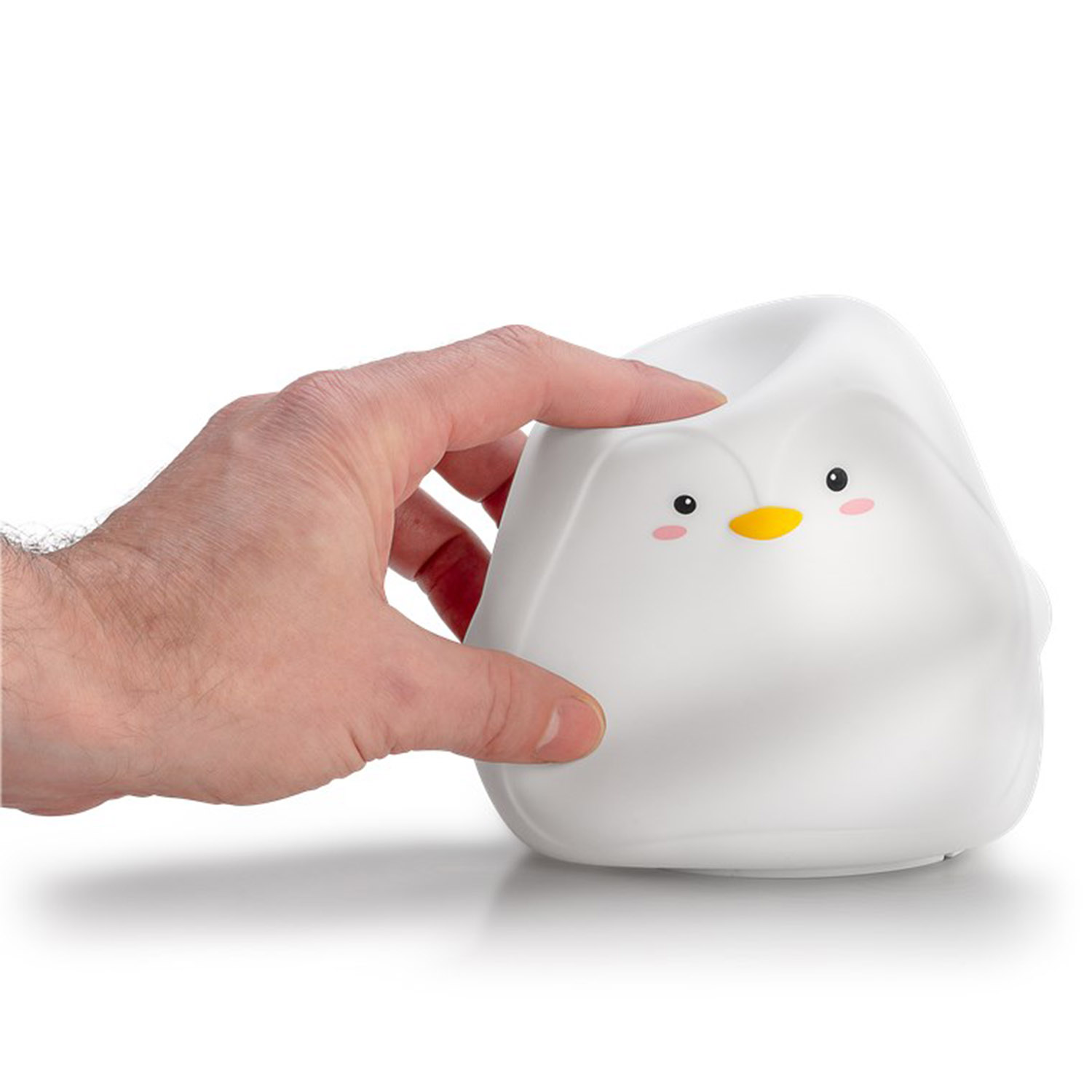 Ein weißes pinguinförmiges Nachtlicht, das von einer Hand vor weißem Hintergrund gehalten wird.