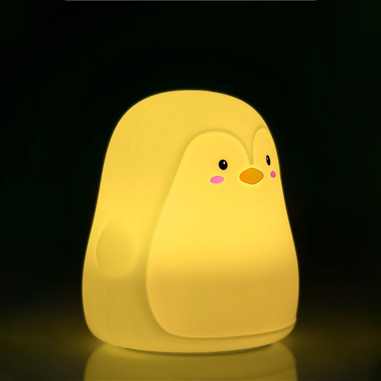 Ein gelbes pinguinförmiges Nachtlicht, das auf schwarzem Hintergrund leuchtet.
