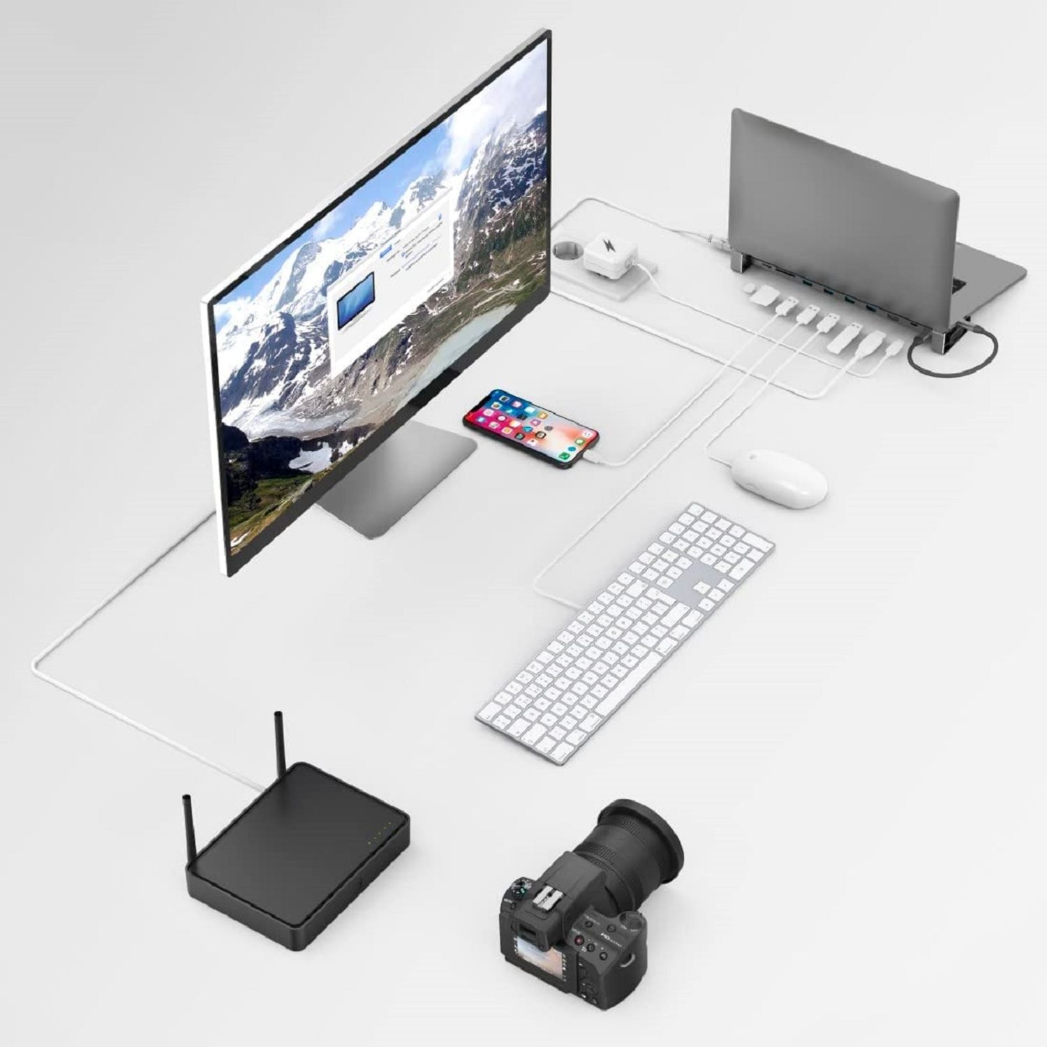 Desktop-Setup mit verschiedenen Geräten: Monitor, Laptop, Telefon, Kamera usw. Weißer Hintergrund.
