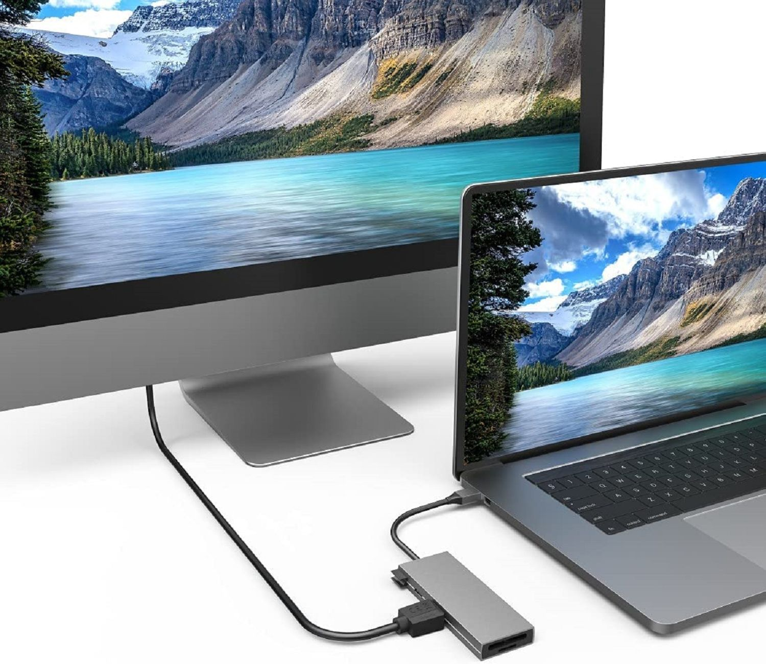 Laptop mit Monitor und Hub verbunden, zeigt eine Naturszene auf beiden Bildschirmen.