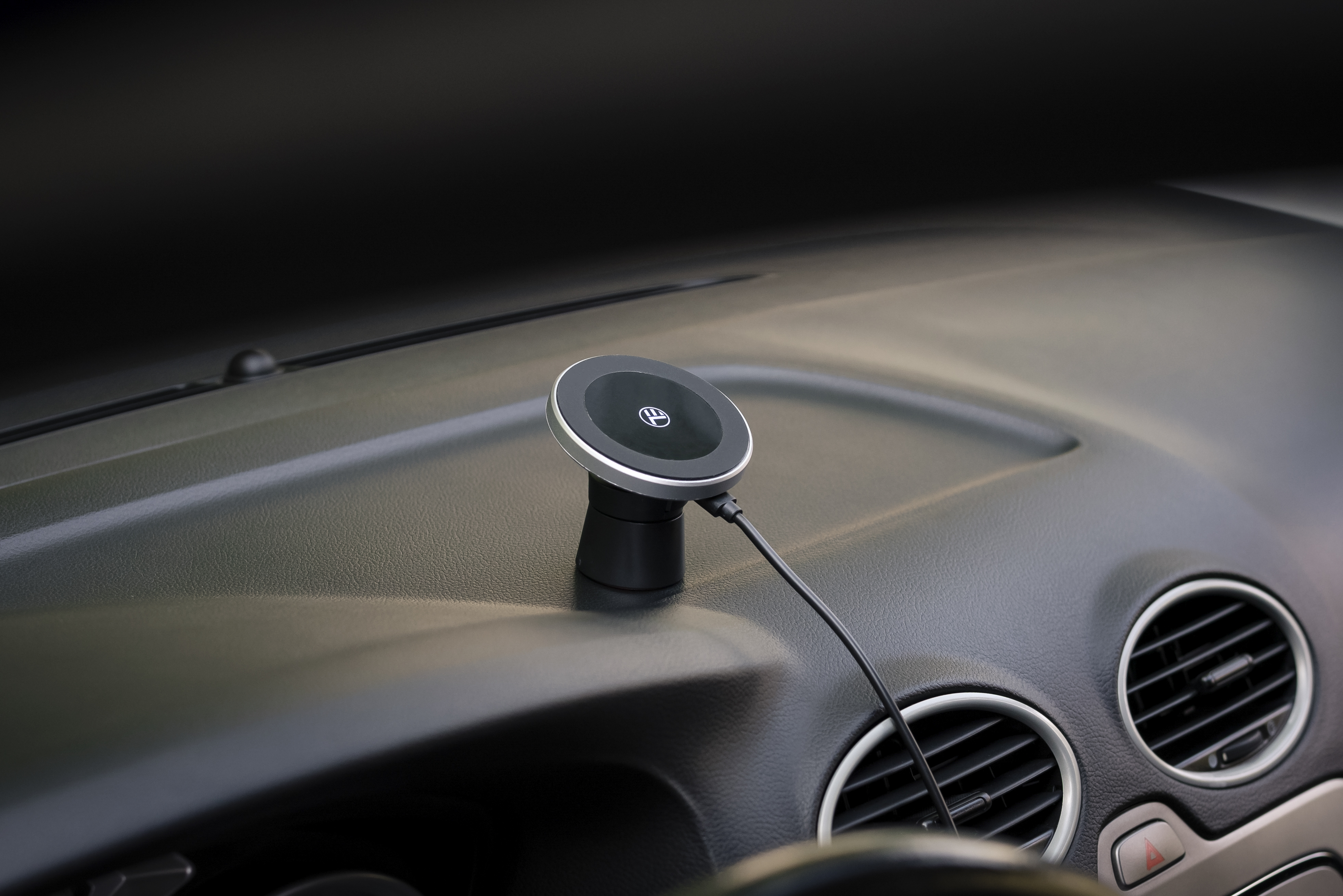 Magnetyczny uchwyt samochodowy na desce rozdzielczej z kablem ładującym.