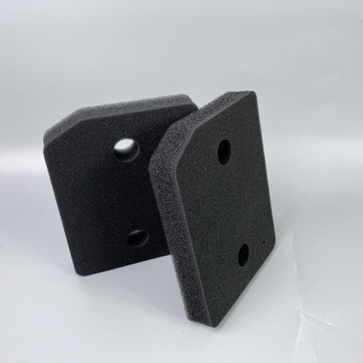 Dwa czarne filtry piankowe z otworami.