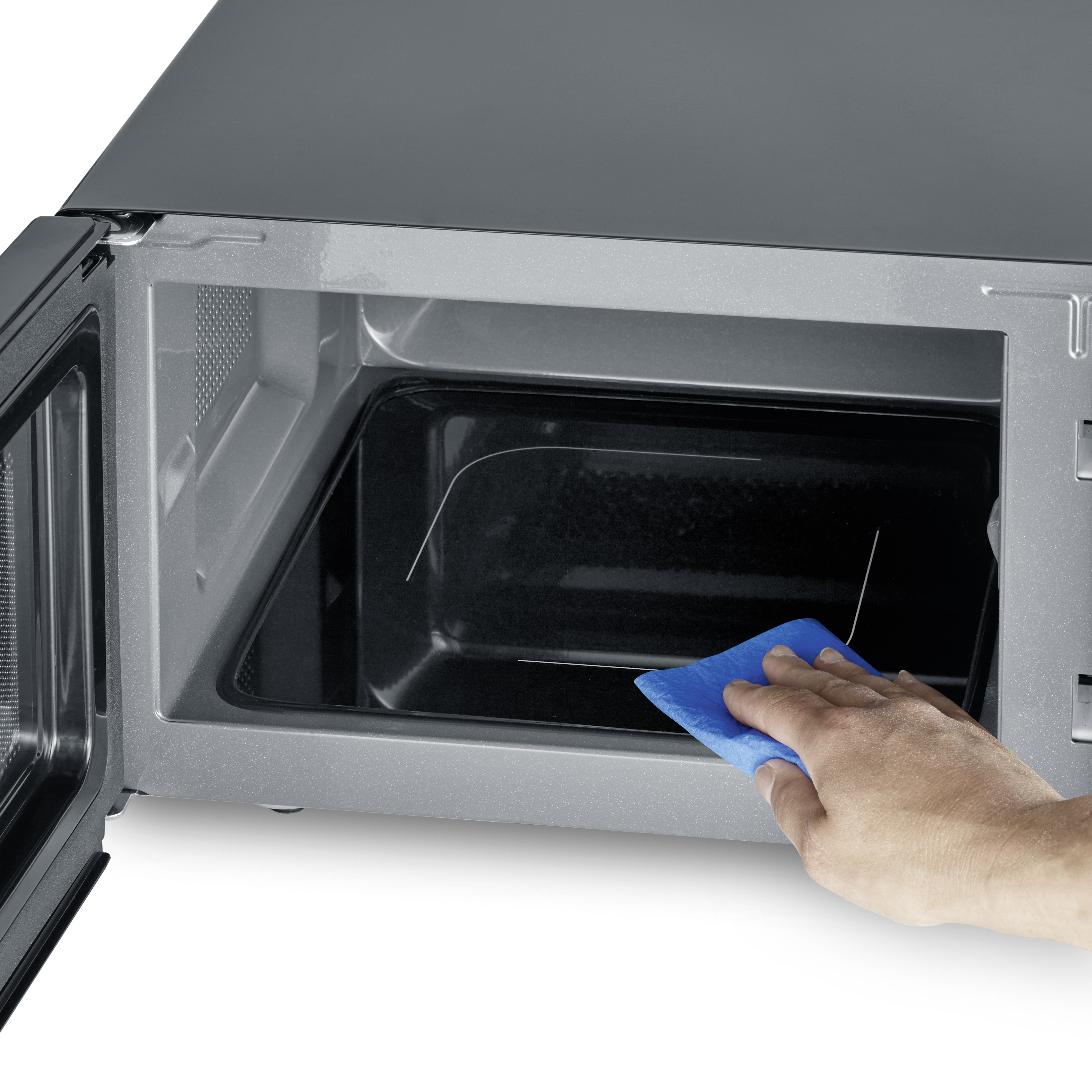Piekarnik mikrofalowy z otwartymi drzwiami i dłonią trzymającą niebieską szmatkę w środku.