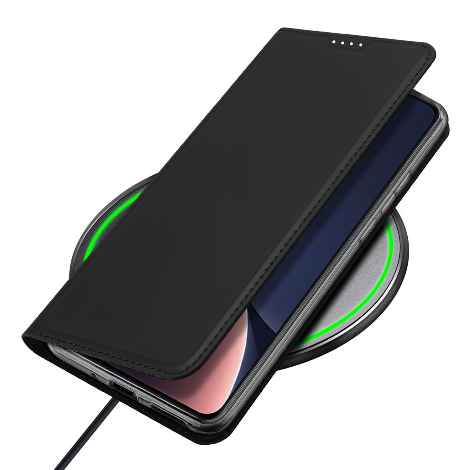 Telefono nero in una custodia nera su un caricatore wireless. Il caricatore ha un bagliore verde.