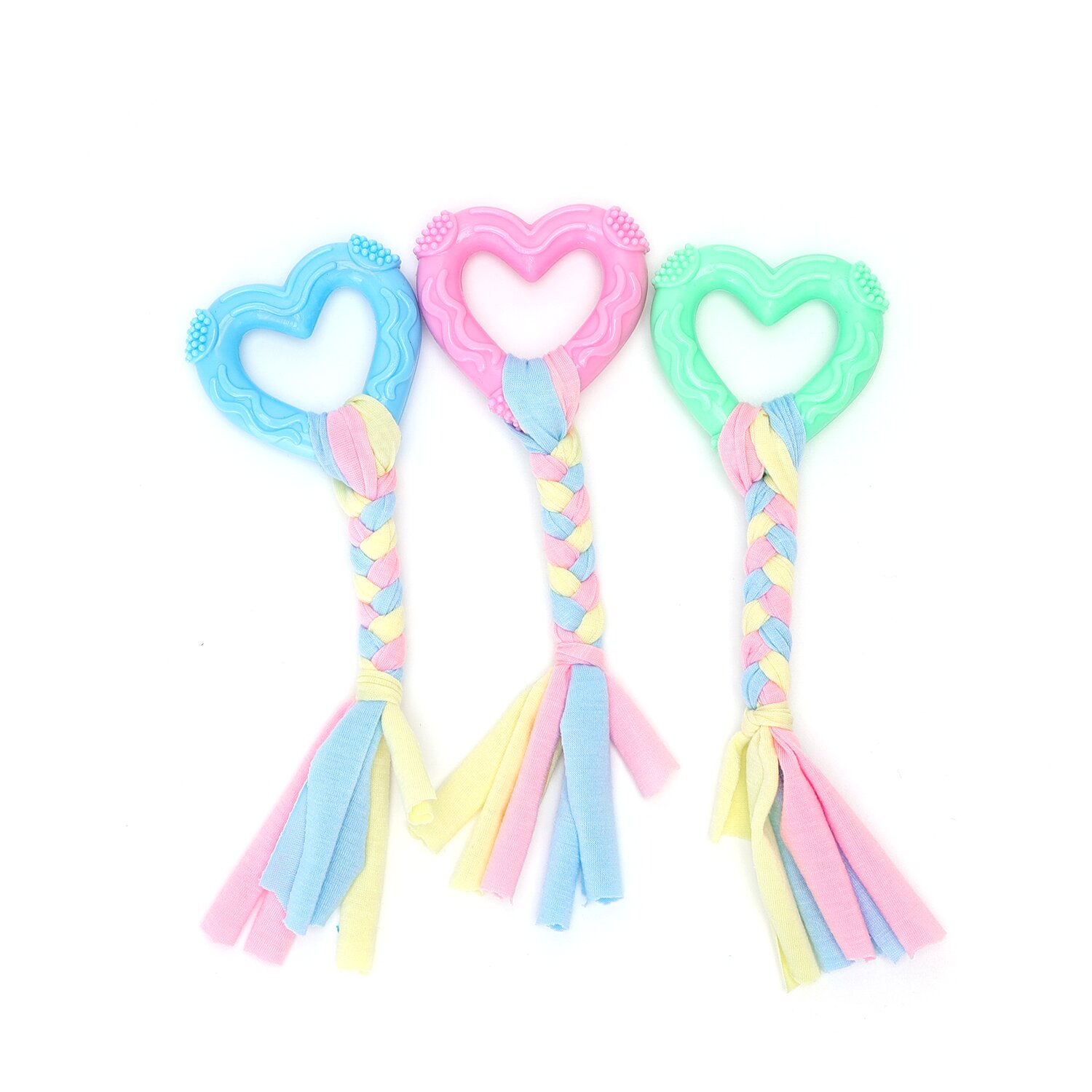 Tre giocattoli per cani a forma di cuore con manici intrecciati e nappe di tessuto, blu, rosa e verde, su bianco.