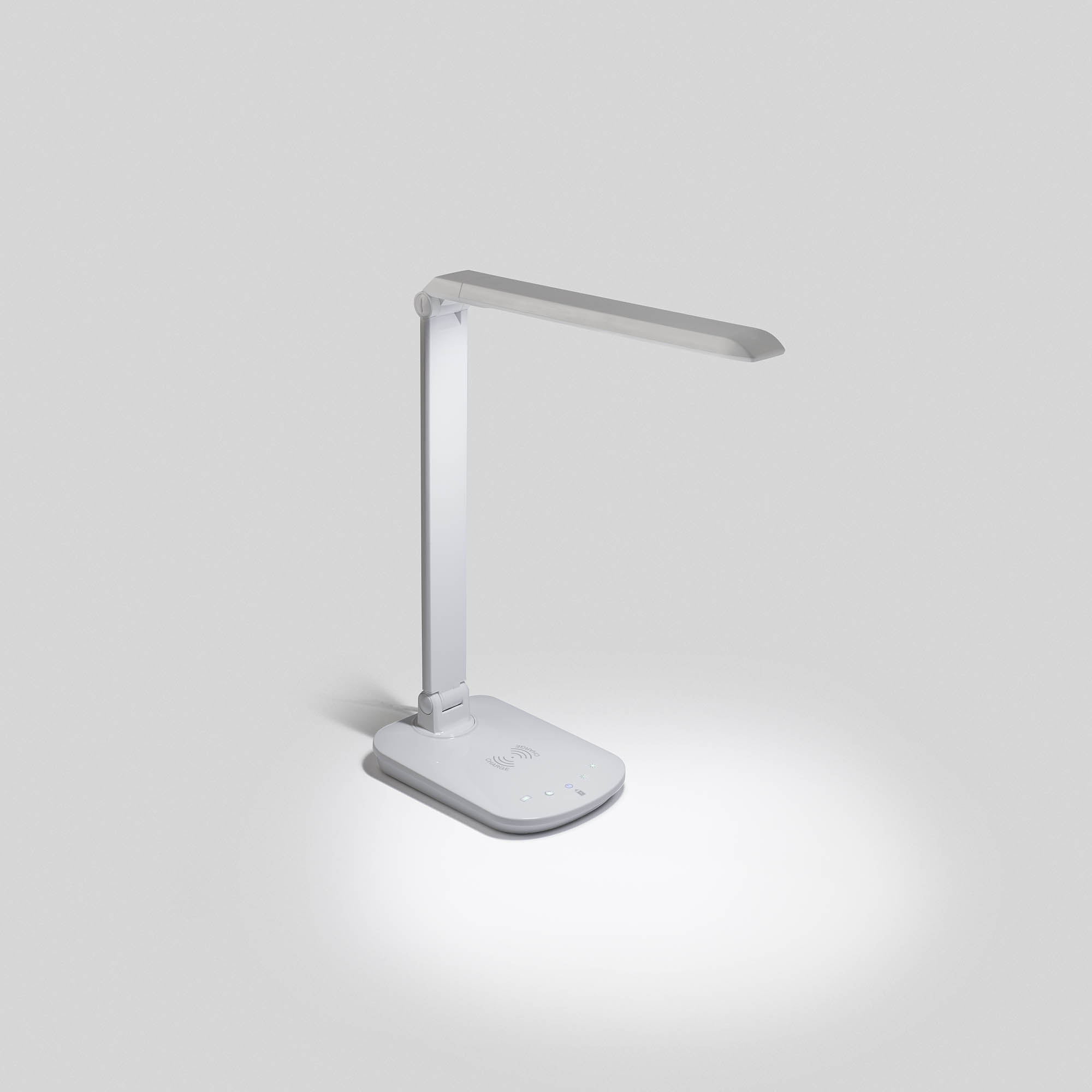 Lampada da scrivania bianca con testa rettangolare e base rotonda, su superficie bianca.