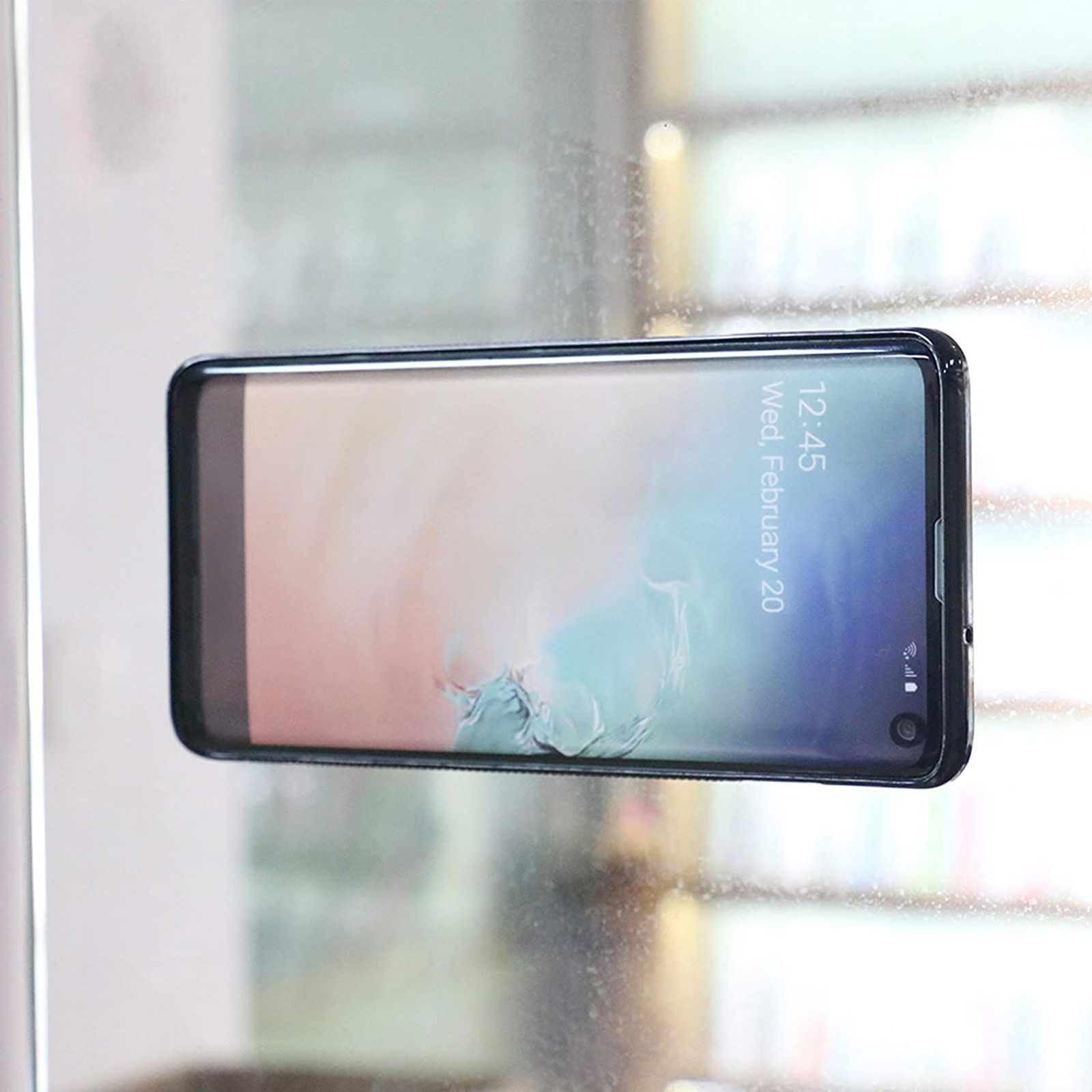 Smartphone mit Uhrzeit, schwarzes Gehäuse auf heller Oberfläche. Der Bildschirm zeigt den 20. Februar.
