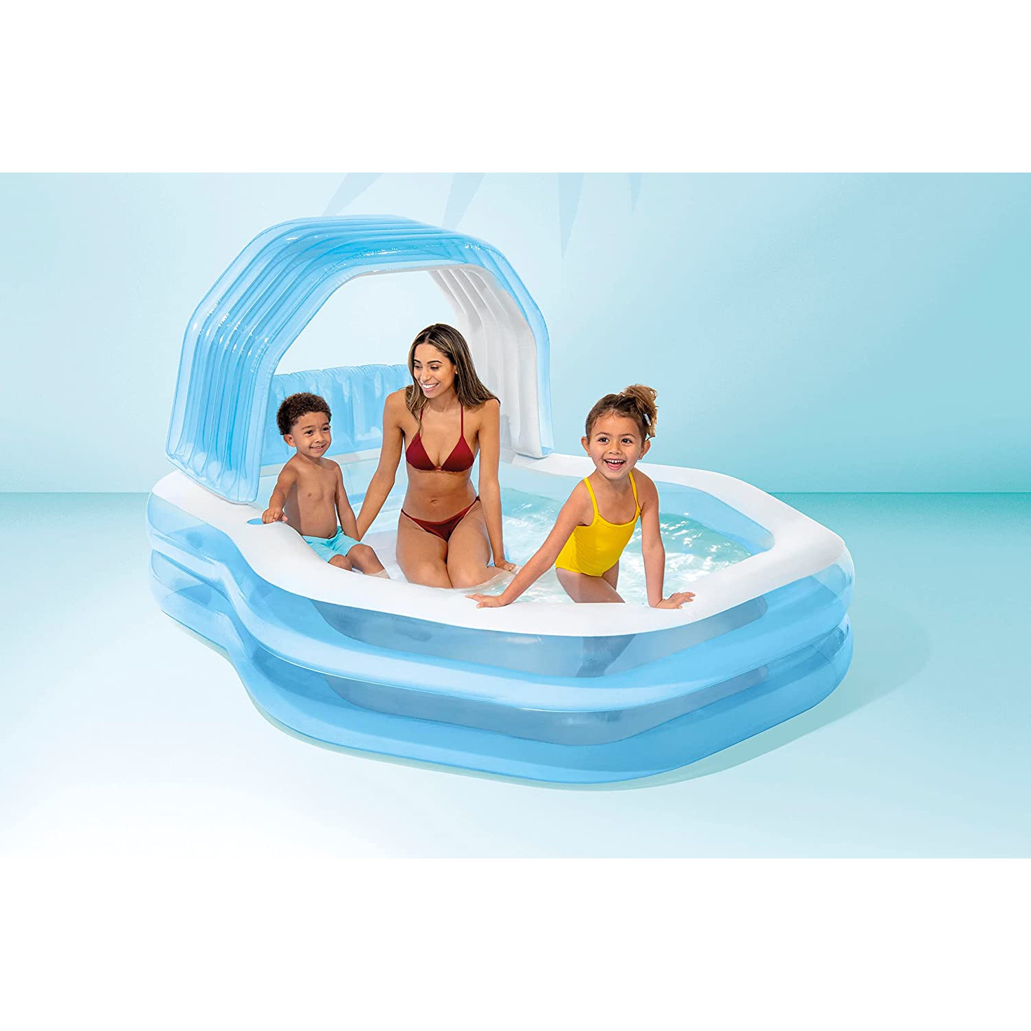 Pool mit drei Personen darin. Ein Erwachsener und zwei Kinder, einer mit blauem Verdeck.