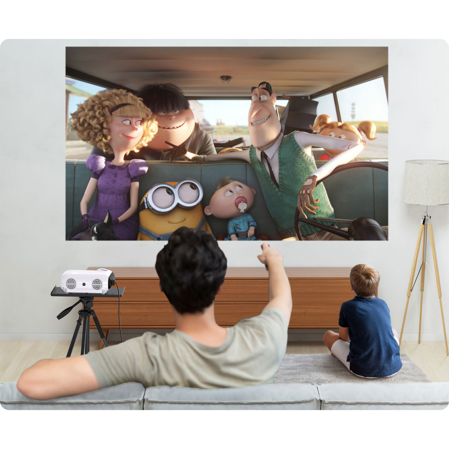 Familie schaut einen Film, der auf eine weiße Leinwand projiziert wird. Enthält einen Projektor und eine Lampe.