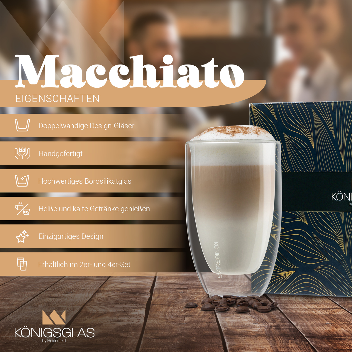Macchiato in einem Glasbecher mit Kaffeebohnen, Text und einer Schachtel auf einem Holztisch.