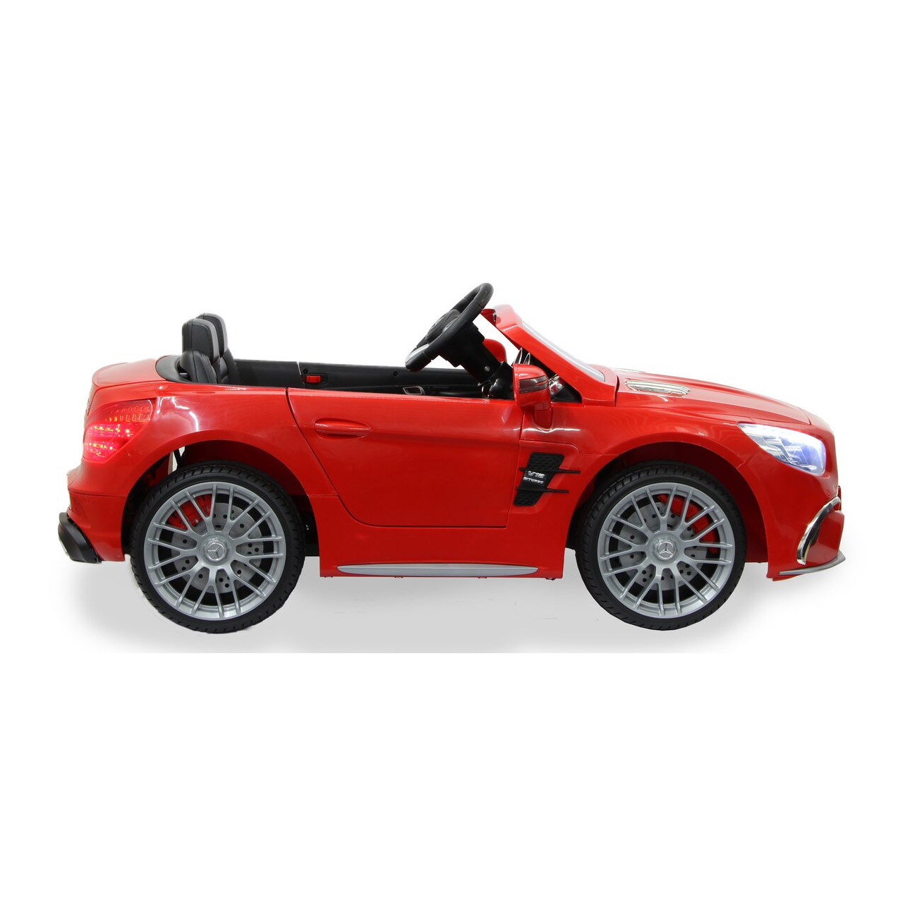 Rotes Spielzeugauto mit schwarzen Sitzen, Rädern und Lenkrad. Auf weißem Hintergrund.