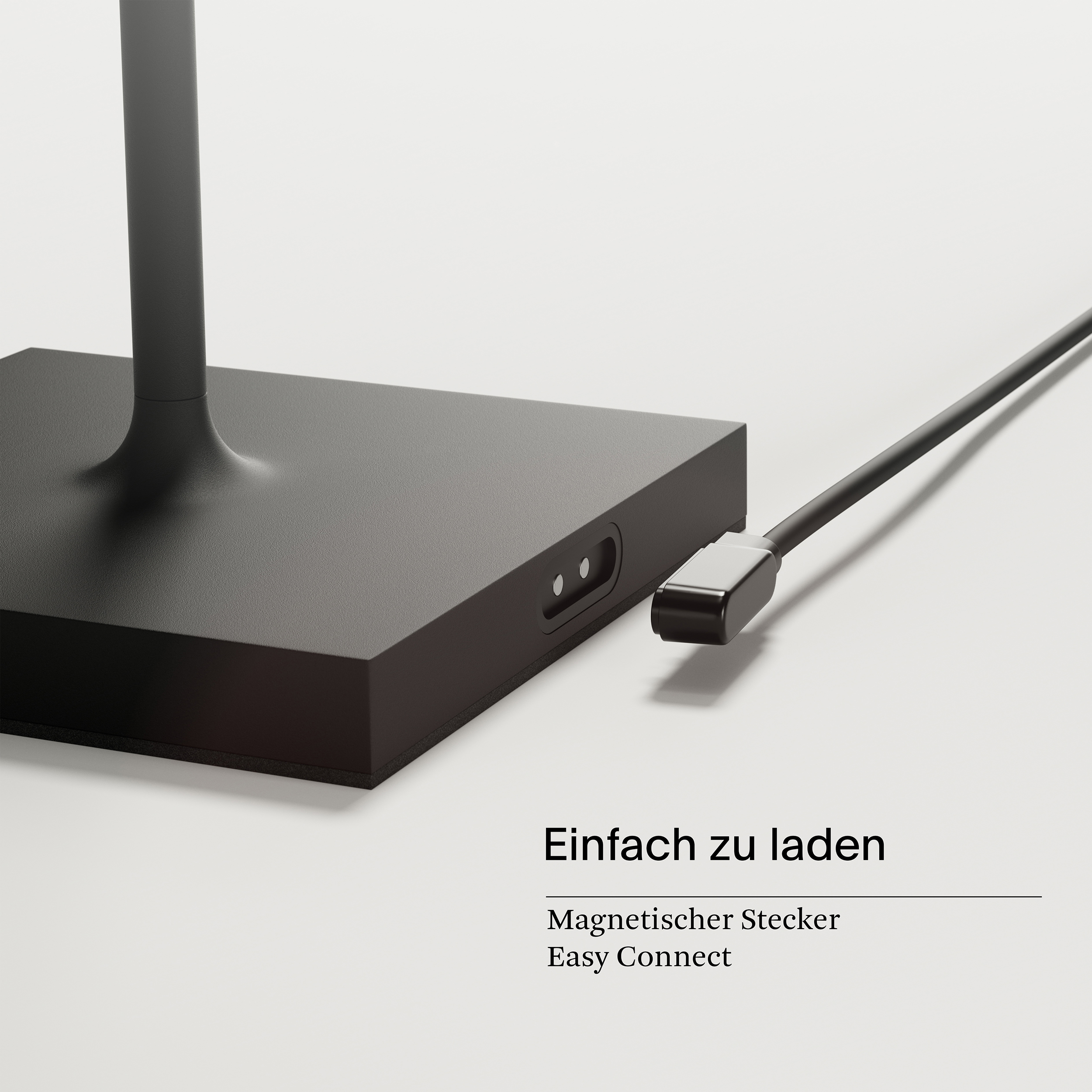 Schwarzer Lampensockel mit Ladeanschluss und schwarzem Kabel, weißer Hintergrund.