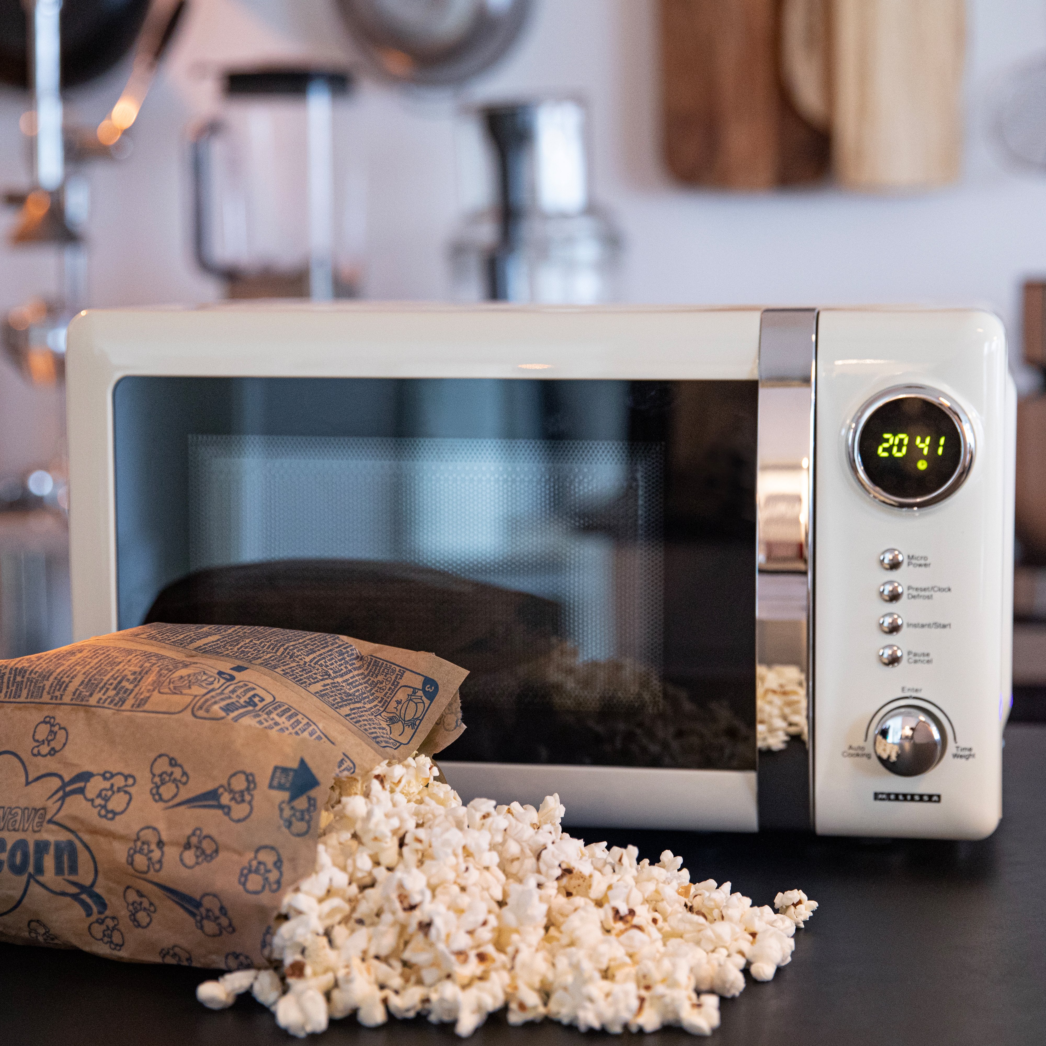 Un microonde con popcorn, un sacchetto di popcorn e l'ora 20:41 visualizzata.