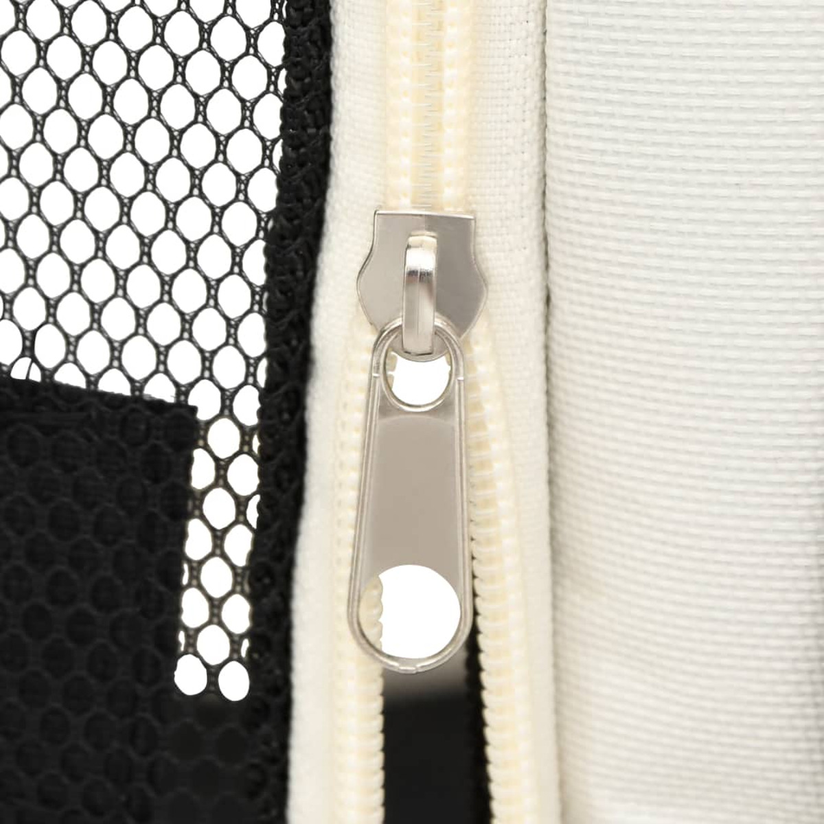 Nahaufnahme eines Reißverschlusses. Der Reißverschluss befindet sich an einer schwarz-weißen Tasche. Der Zipper ist silberfarben.