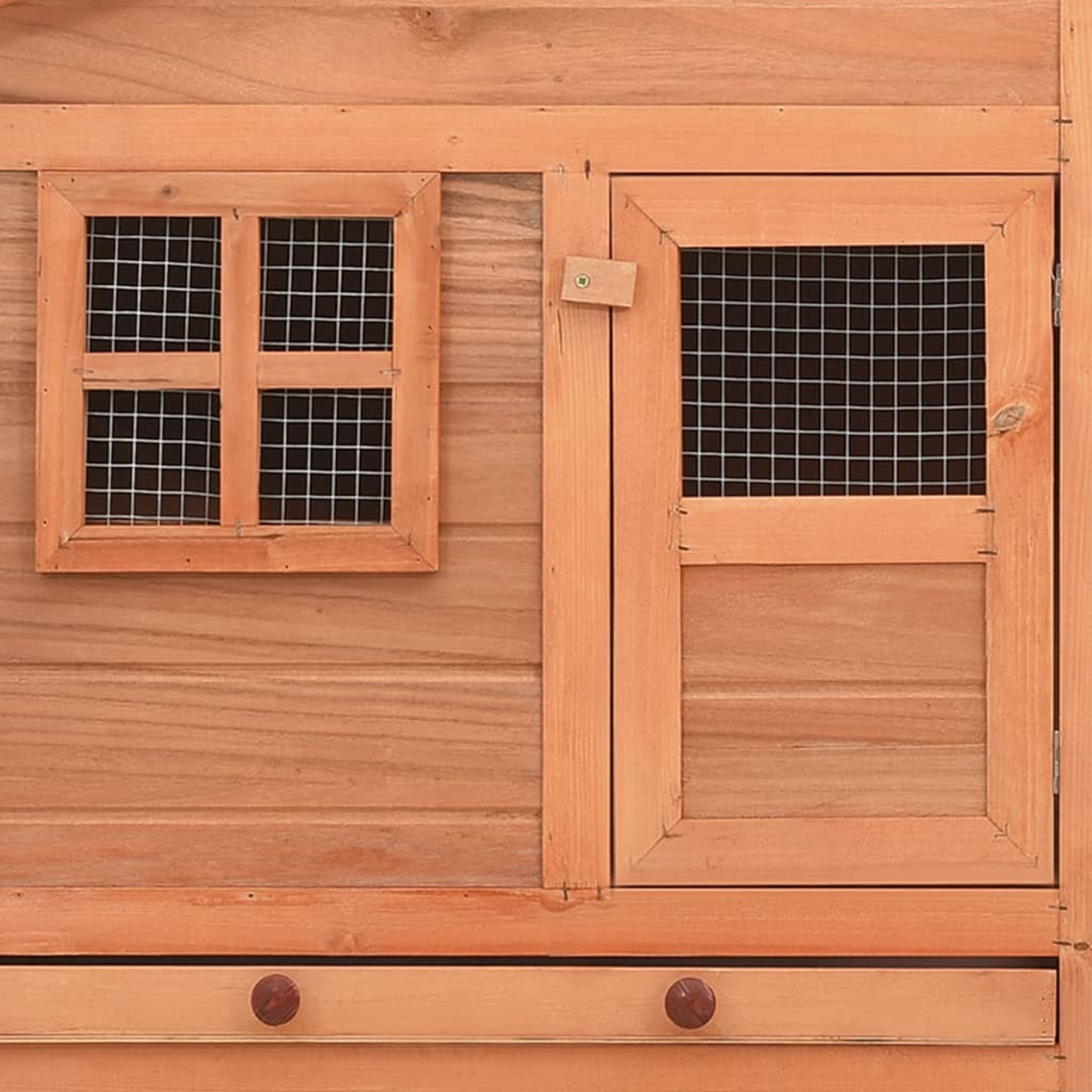 Nahaufnahme eines Vogelhauses aus Holz mit Tür und Fenster, mit Gitter.