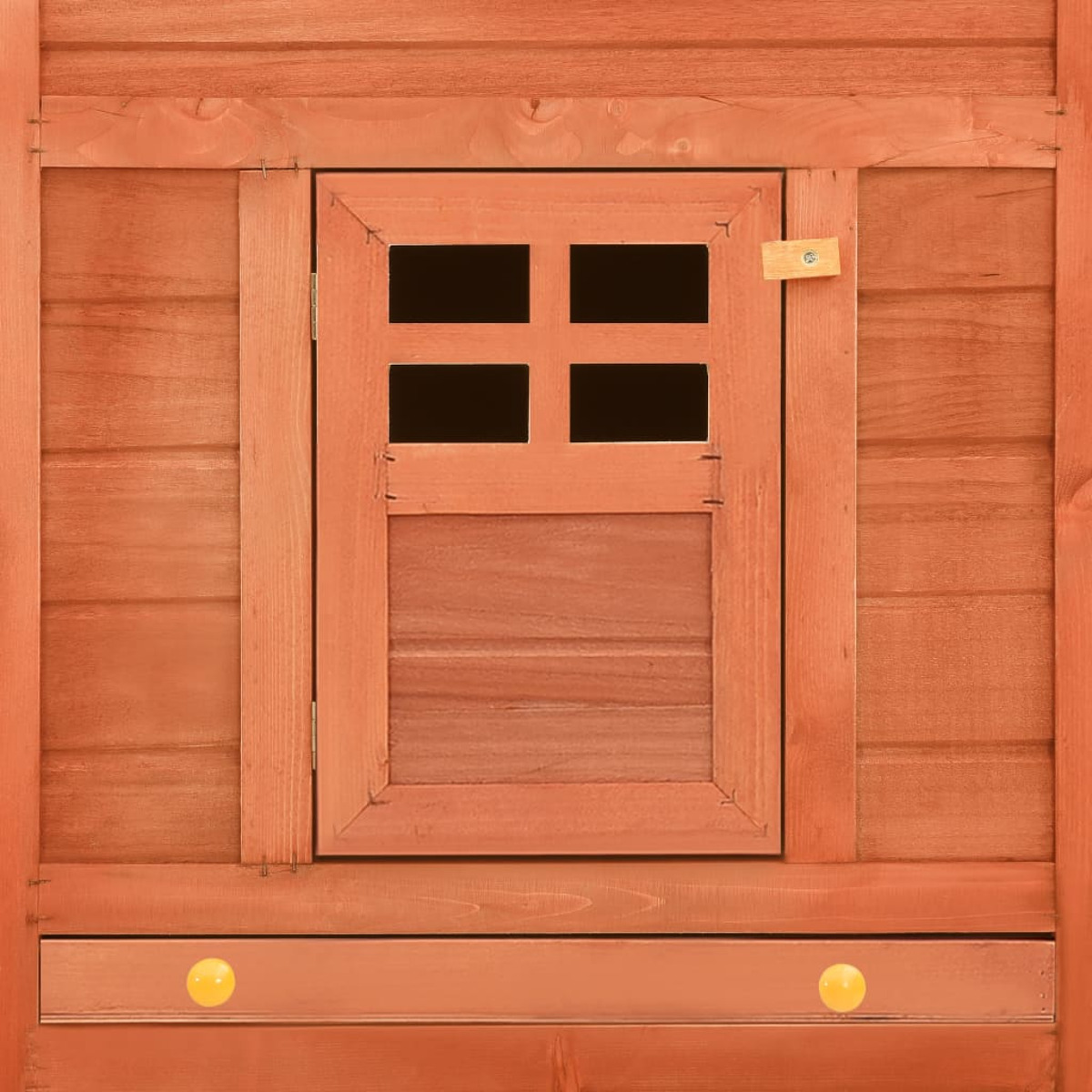Holzfenster eines Spielhauses. Das Fenster ist klein, mit einem viergeteilten Design. Das Haus ist braun.