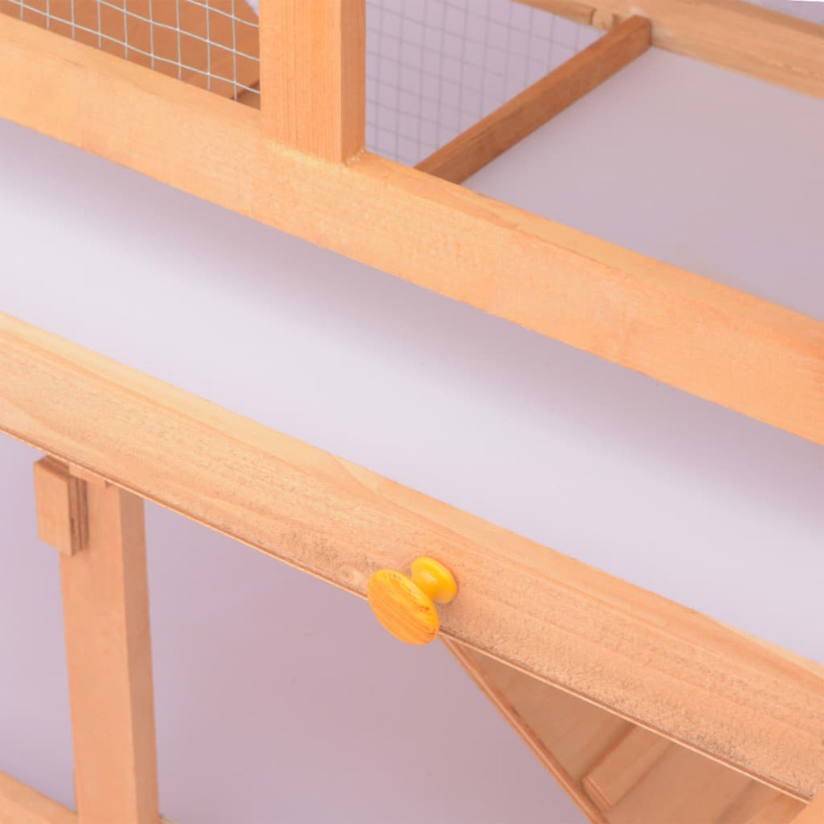 Nahaufnahme eines Vogelkäfigs aus Holz mit Drahtgeflecht. Es hat einen gelben Riegel und eine weiße Basis.