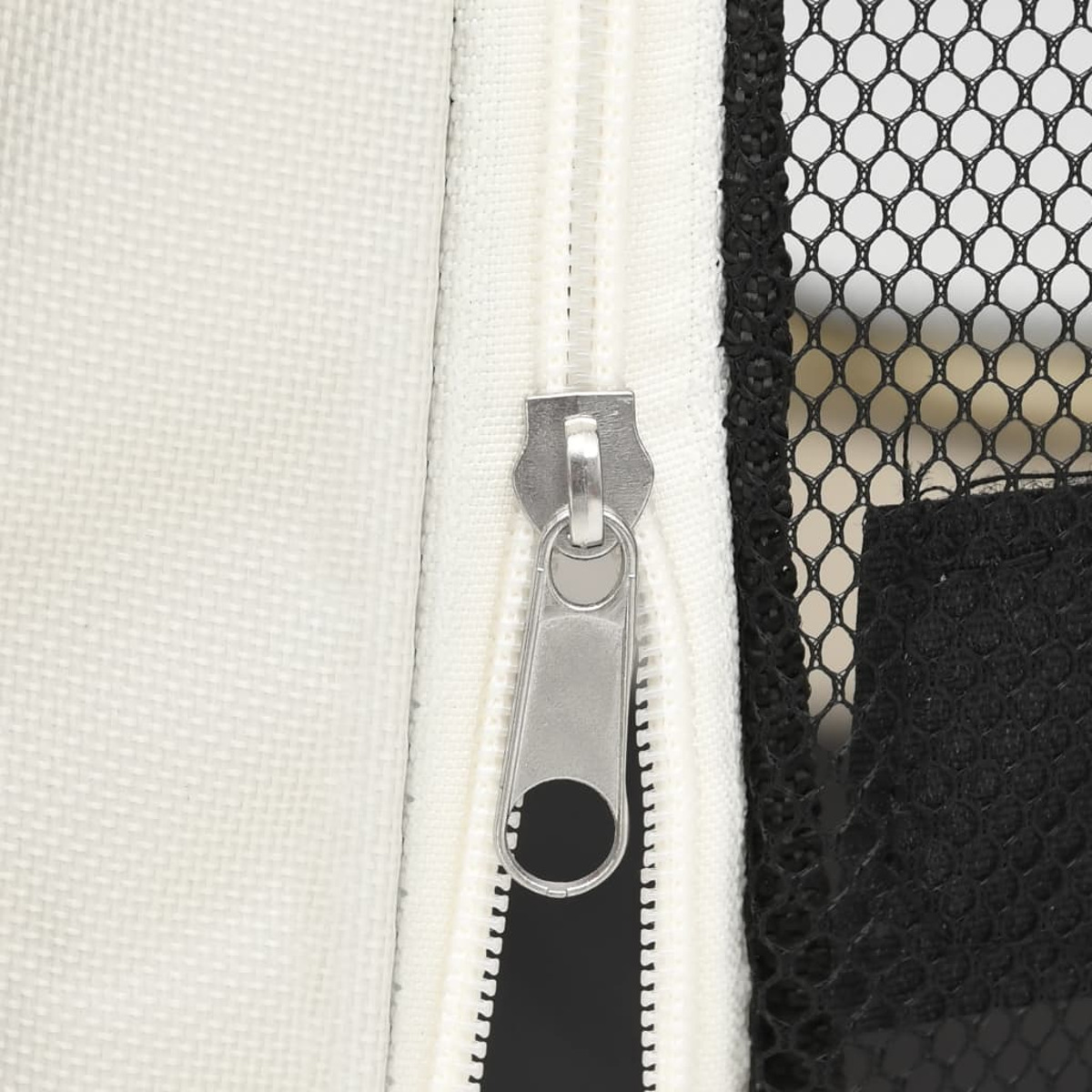 Nahaufnahme eines silbernen Reißverschlusses auf einer weiß-schwarzen Netztasche, die Details des Reißverschlusses zeigt.