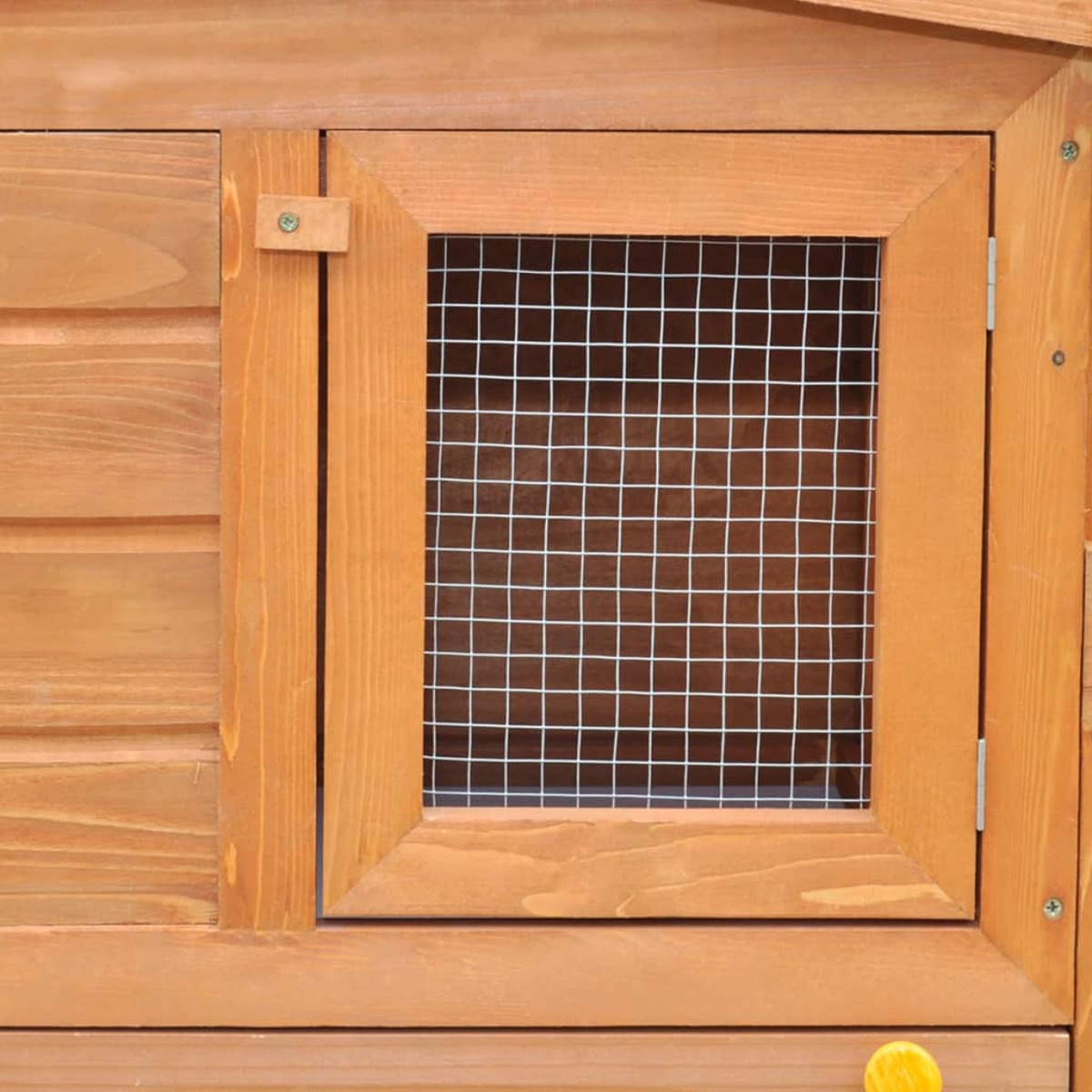 Fenster eines Hühnerstalls aus Holz mit Drahtgeflecht.