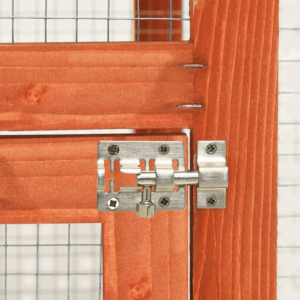 Nahaufnahme eines Metallverschlusses an einer Holztür eines Kaninchenstalls, mit Gitterhintergrund.