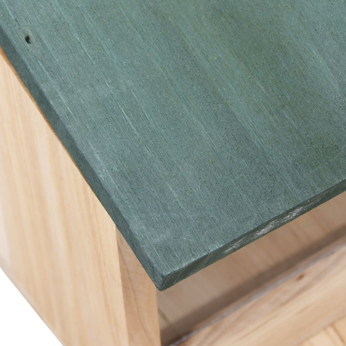 Nahaufnahme eines Vogelhauses aus Holz mit grünem Dach. Helles Holz und Grün.