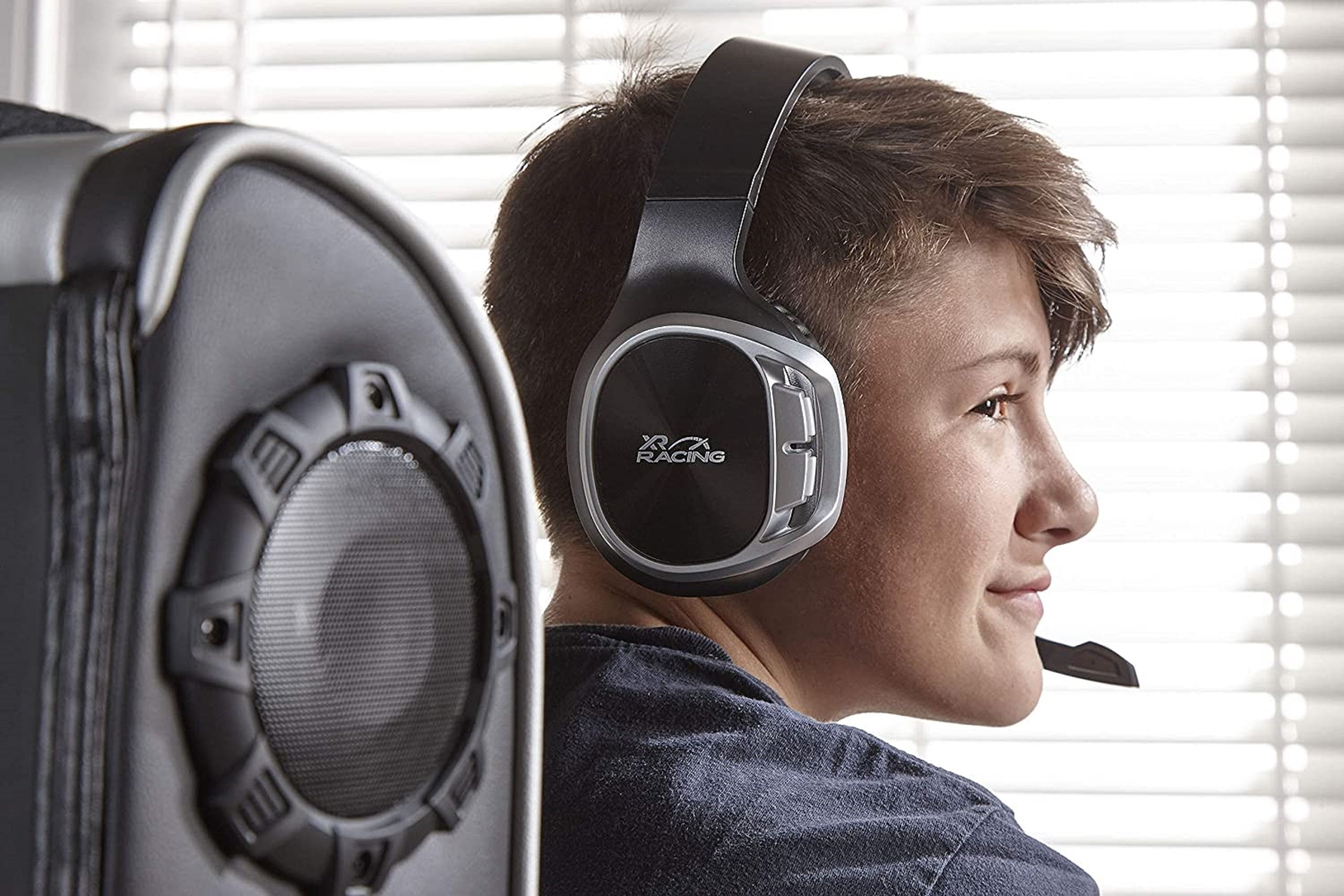 Ein junger Mann mit Gaming-Headset und Mikrofon, lächelnd.