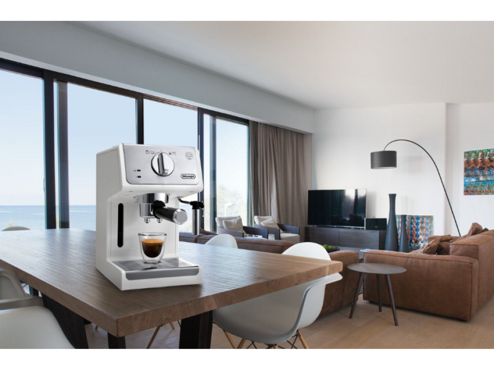 Biały ekspres do espresso na drewnianym stole. Tło: salon ze światłem słonecznym.