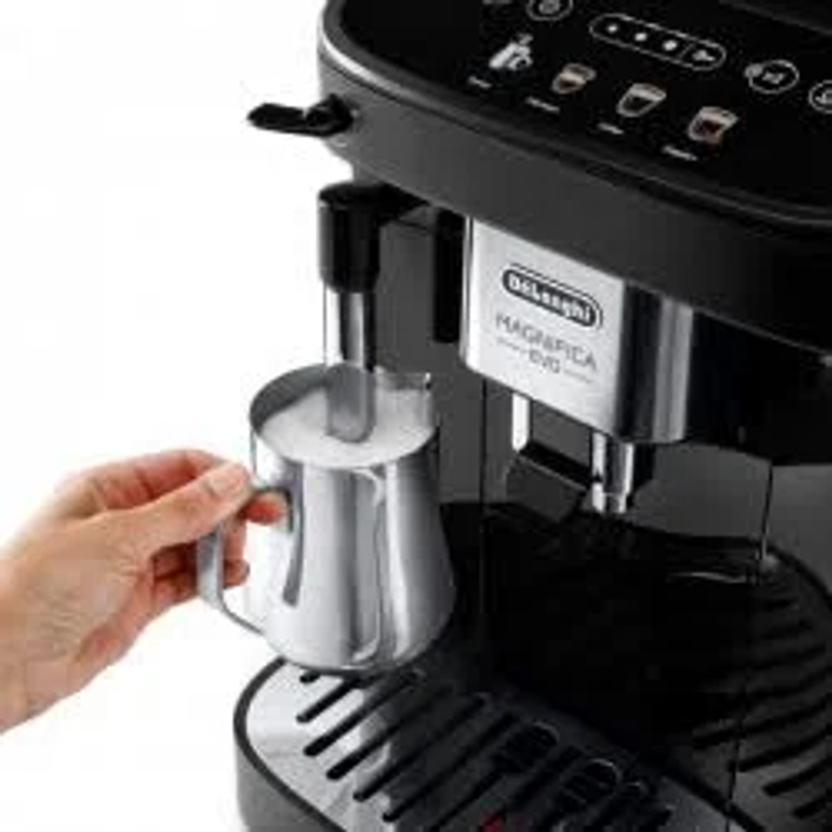 Une machine à expresso Delonghi Magnifica Evo. Une main tient un pot à lait.
