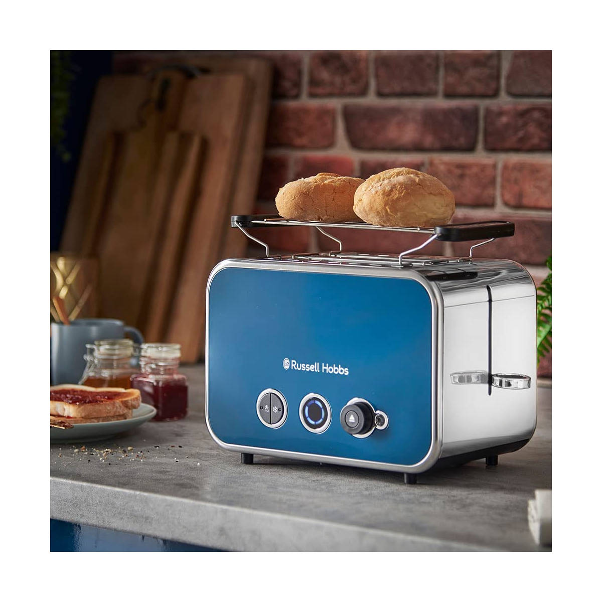 Blauer Russell Hobbs Toaster mit Edelstahl-Akzenten. Toast und Marmelade auf der Theke sichtbar.