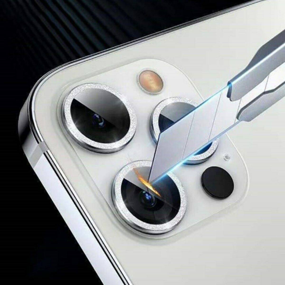 Obiettivi della fotocamera del telefono con protezione applicata da uno strumento.