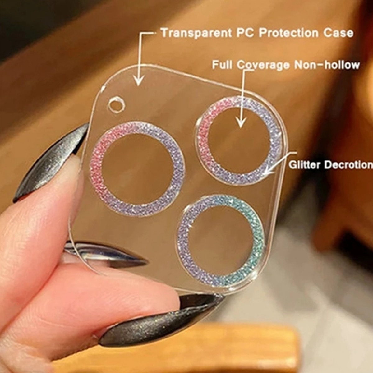 Un proteggi obiettivo per fotocamera del telefono trasparente con glitter attorno ai bordi.