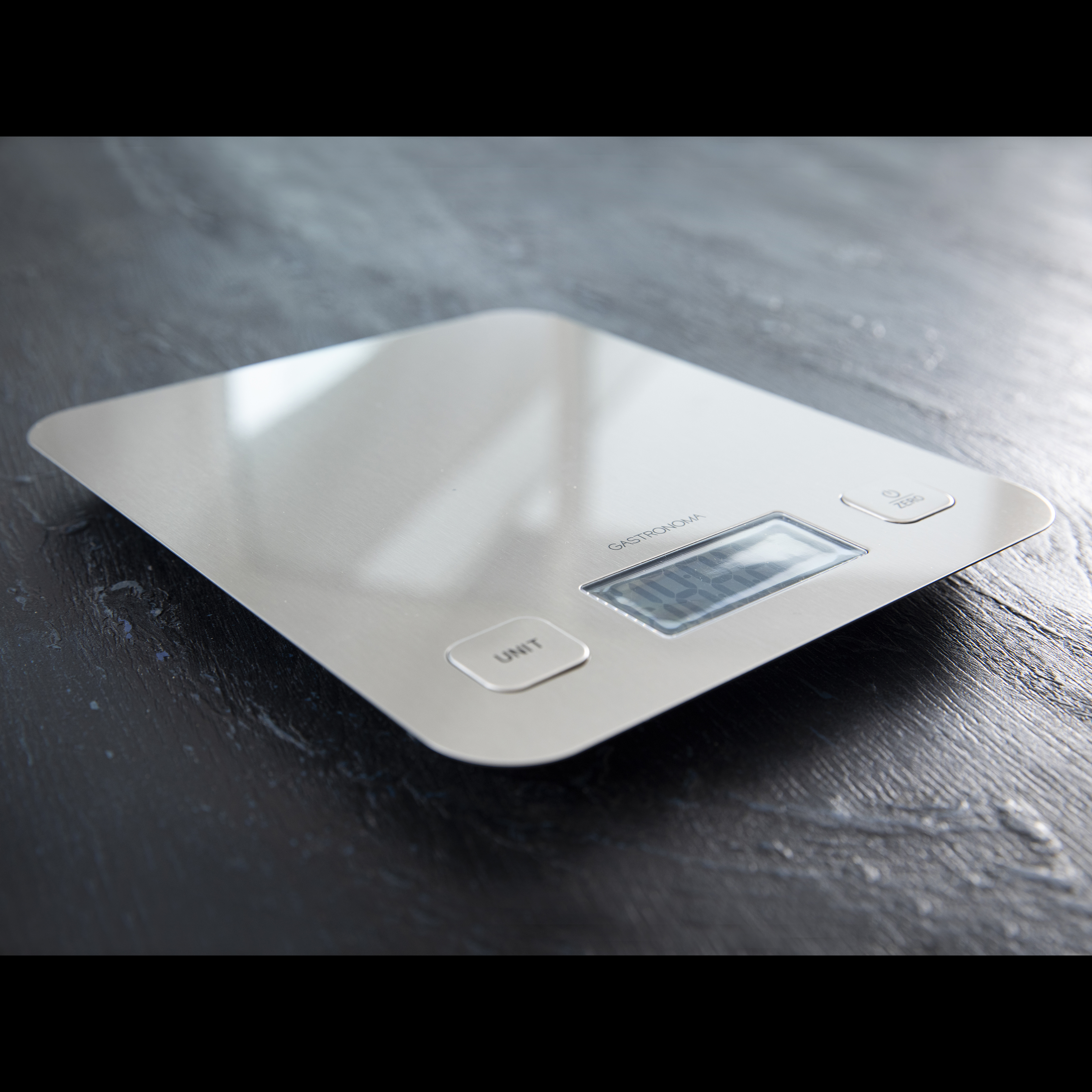 Cyfrowa waga kuchenna Gastronova na ciemnej drewnianej powierzchni.
