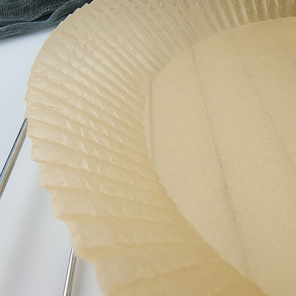 Nahaufnahme einer Papierbackform mit geriffelten Kanten.