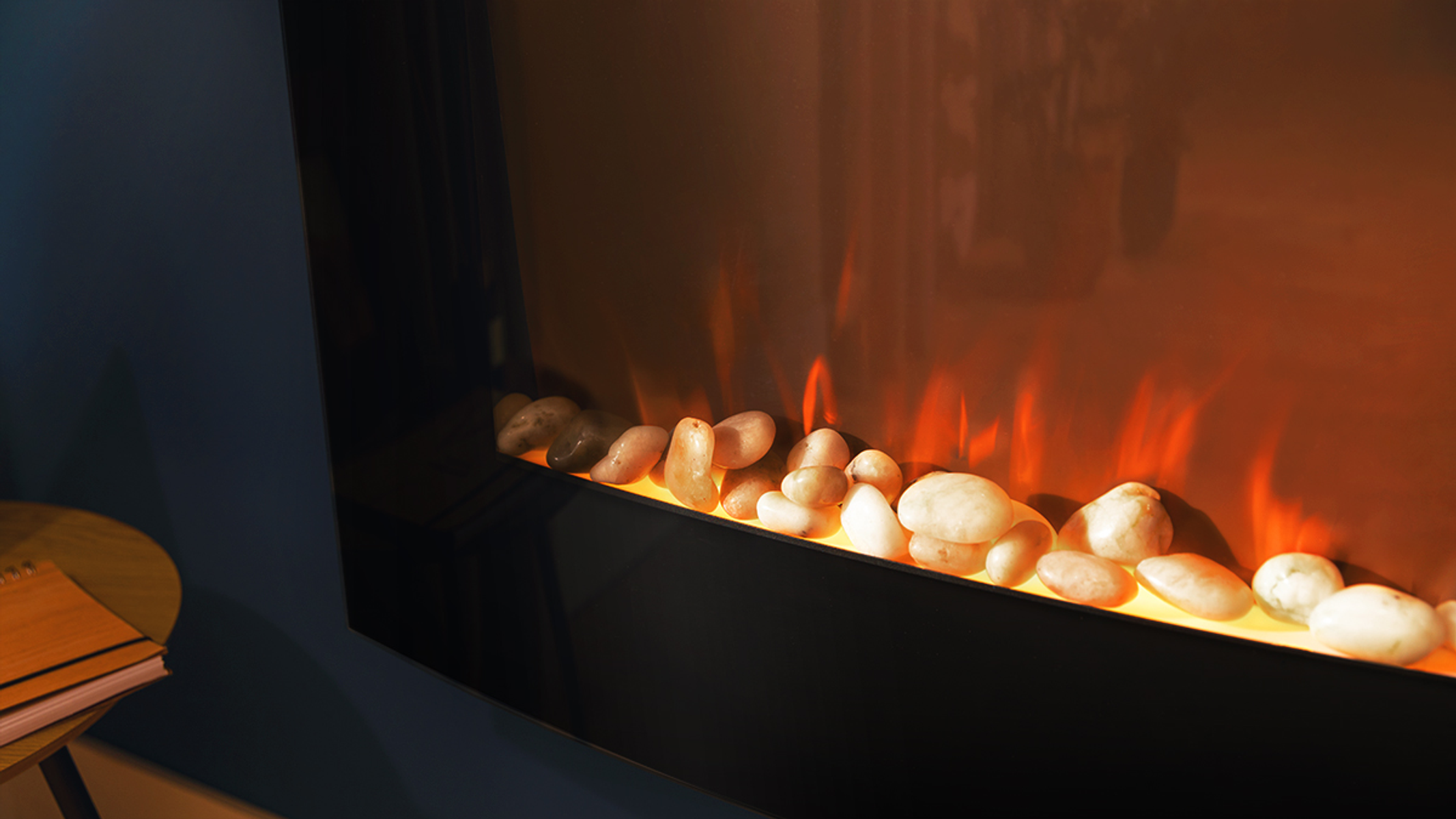 Una chimenea eléctrica con marco negro. Se ven llamas y piedras artificiales.