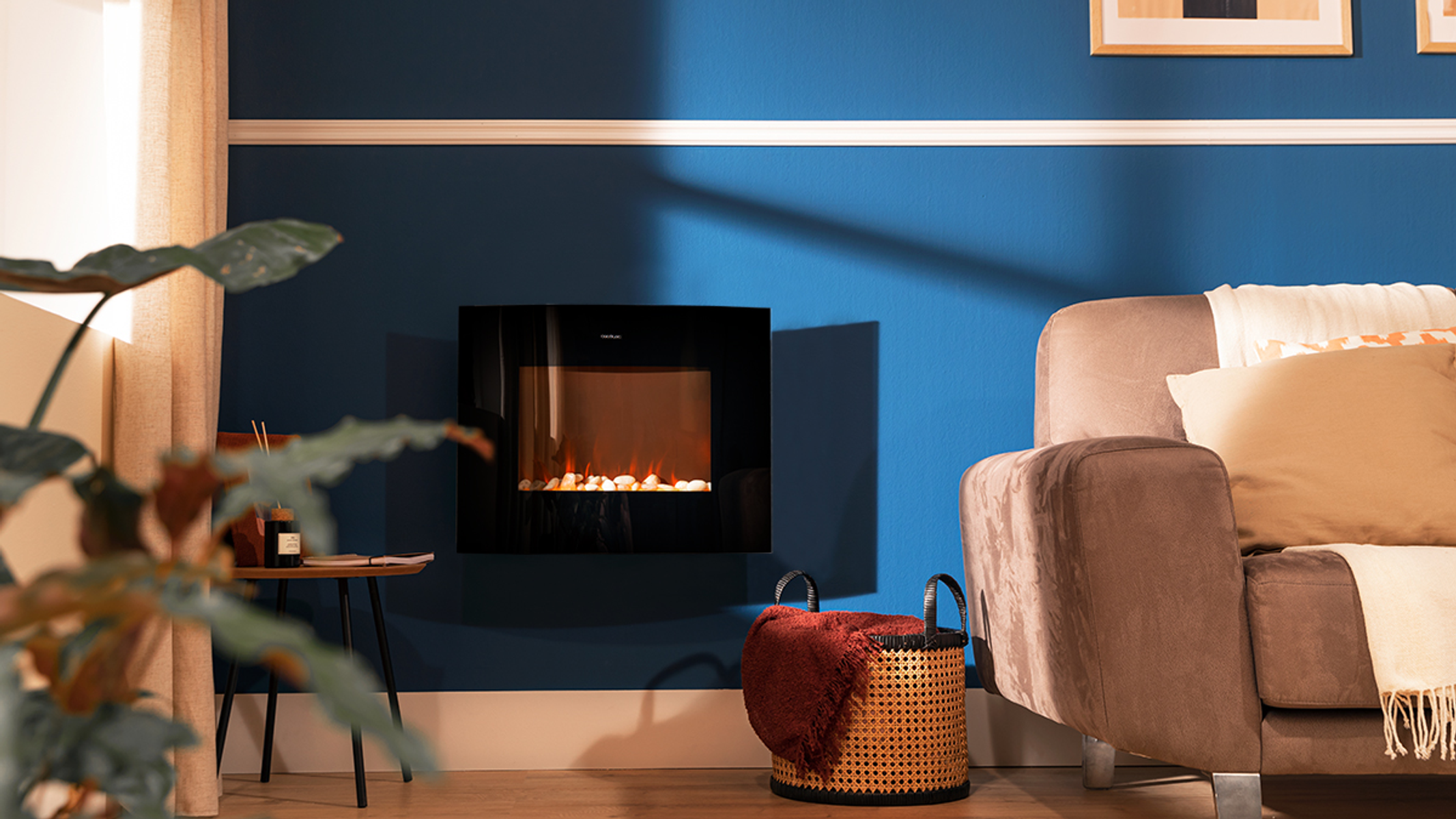 Una chimenea negra está montada en una pared azul. Un sofá marrón y una cesta de mimbre a la derecha.