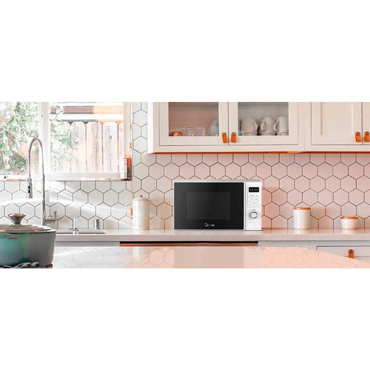 Horno microondas blanco en una cocina luminosa con armarios blancos.